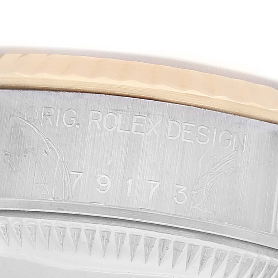 The image shows a close-up of the side engraving on a Rolex Datejust 79173 Women's Steel and Gold (two tone) Black Dial, highlighting the model number and design details.