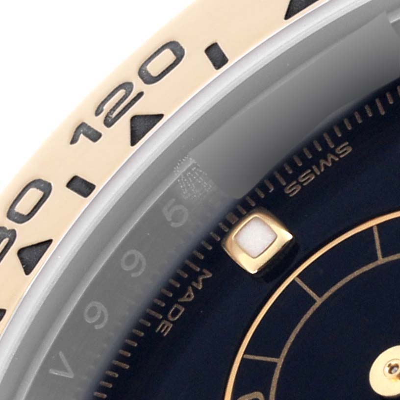 The image shows a close-up of the bezel and part of the dial of a Rolex Daytona 116503 Men
s Steel and Gold (two tone) Black Dial 116503 Men
s Steel and Gold (two tone) Black Dial watch, highlighting the numerals and markers.