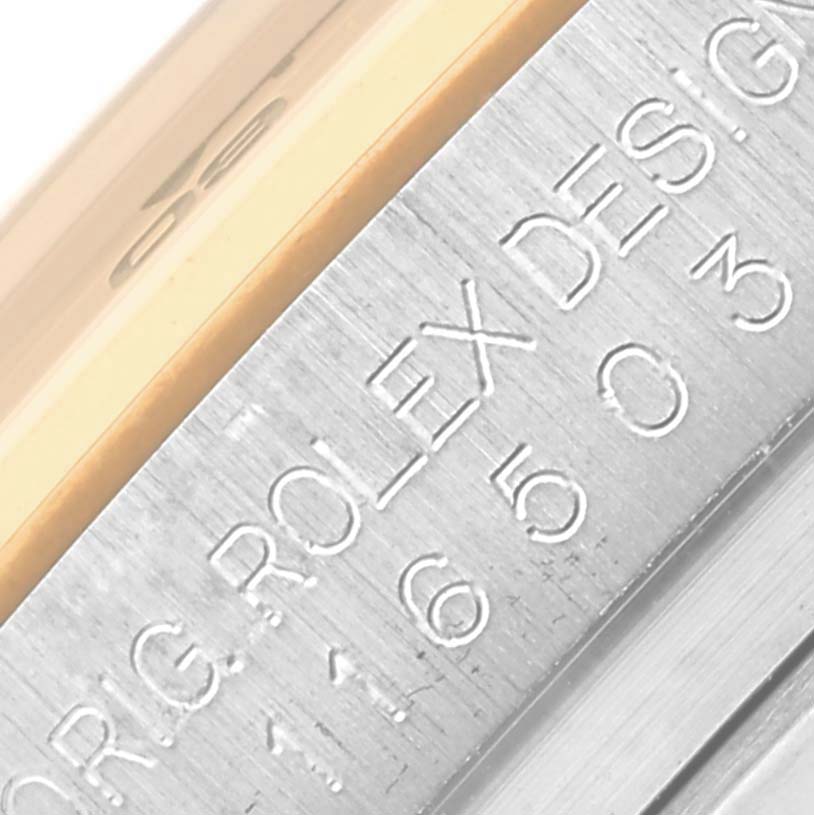 The image shows a close-up of the engraved bezel on a Rolex Daytona 116503 Men
s Steel and Gold (two tone) Black Dial 116503 Men
s Steel and Gold (two tone) Black Dial.