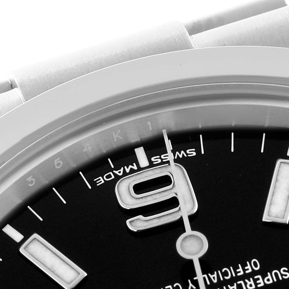 The image shows a close-up of the Rolex Explorer 214270 Men
s Stainless Steel Black Dial 214270 Men
s Stainless Steel Black Dial watch face, highlighting the numeral "9" and part of the bezel and dial.