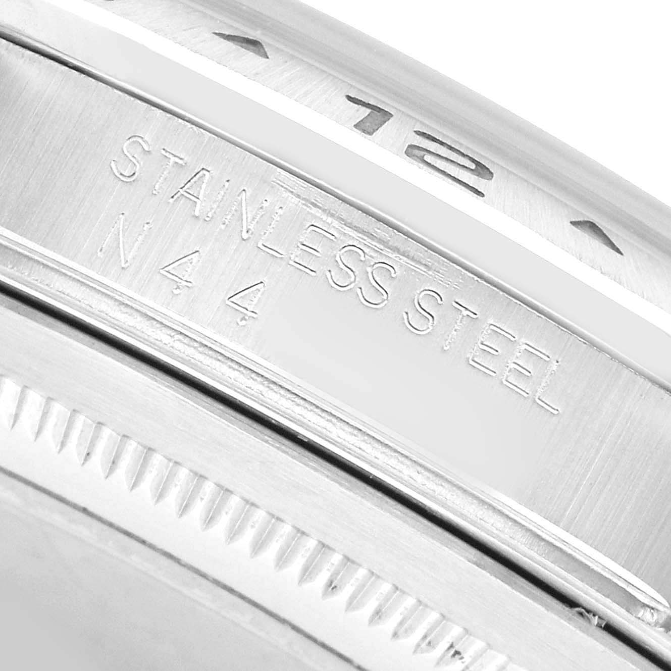 The image shows a close-up of the bezel and side engraving on a Rolex Explorer 16570 Men's Stainless Steel White Dial watch, highlighting the "STAINLESS STEEL" marking.