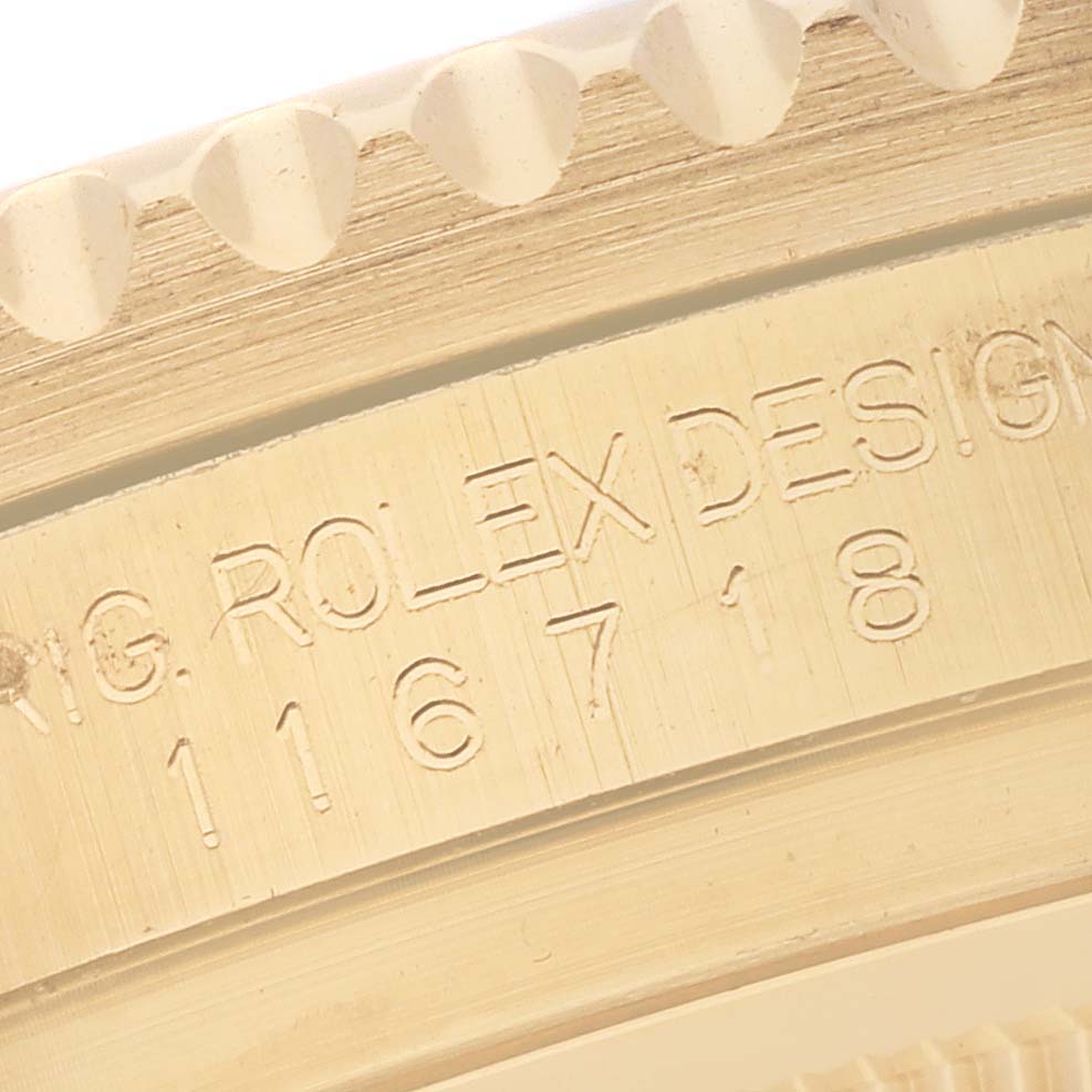 This image shows a close-up of the Rolex GMT-Master 116718LN Men's Yellow Gold Black Dial 116718LN Men's Yellow Gold Black Dial model's engraved bezel edge and serial/design number on the case.