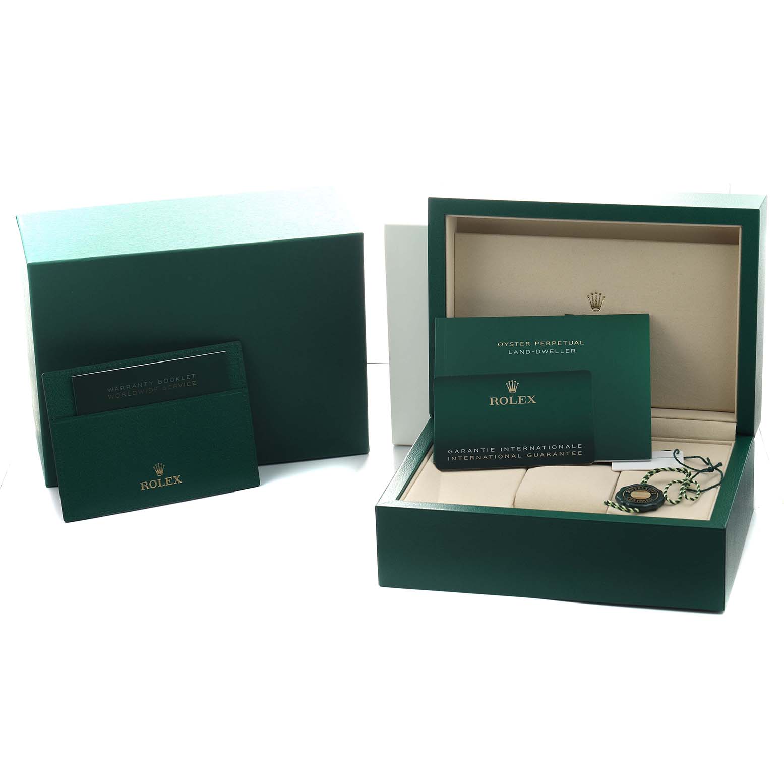 The image shows the packaging and accessories for the Rolex Land-Dweller, including boxes, booklets, and a tag, from a top angle.