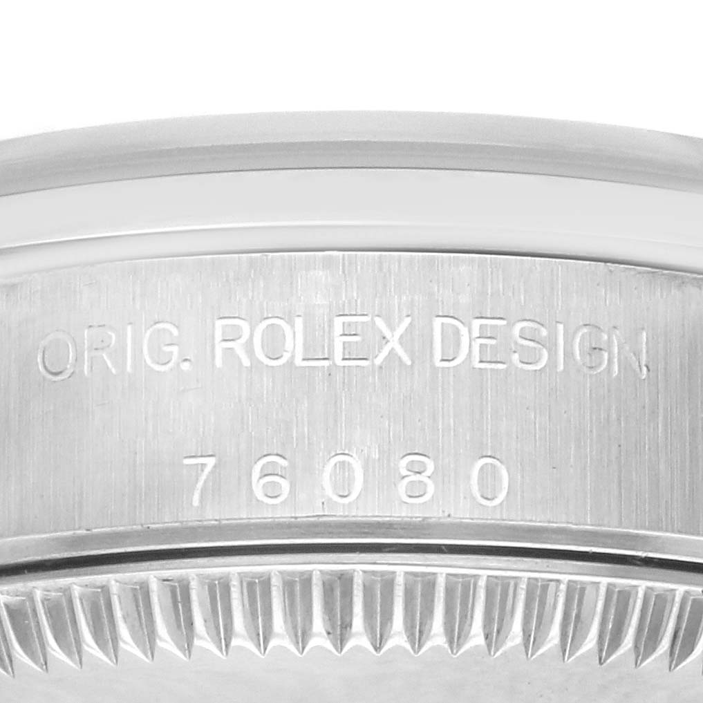 The image shows the engraved side of a Rolex Oyster Perpetual 76080 Women's Stainless Steel Pink Dial 76080 Women's Stainless Steel Pink Dial case, featuring model number and branding.