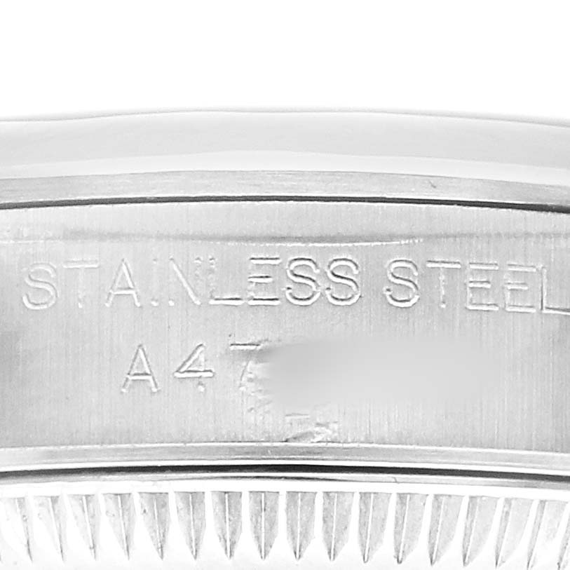 The image shows a close-up of the stainless steel casing and edge of the bezel from a Rolex Datejust 76080 Women's Stainless Steel Black Dial watch.