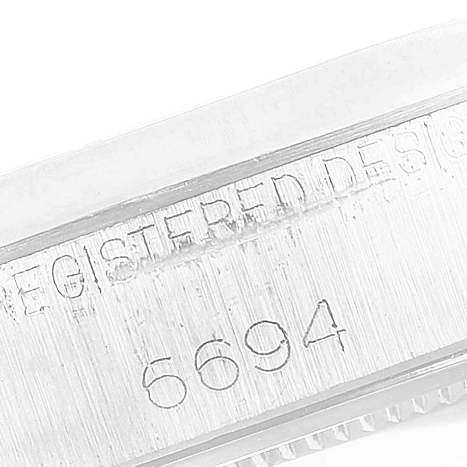 This image shows a close-up of the side of the Rolex Vintage Collection 6694 Men's Stainless Steel Black Dial 6694 Men's Stainless Steel Black Dial model, particularly focusing on the engraved "6694" serial number.