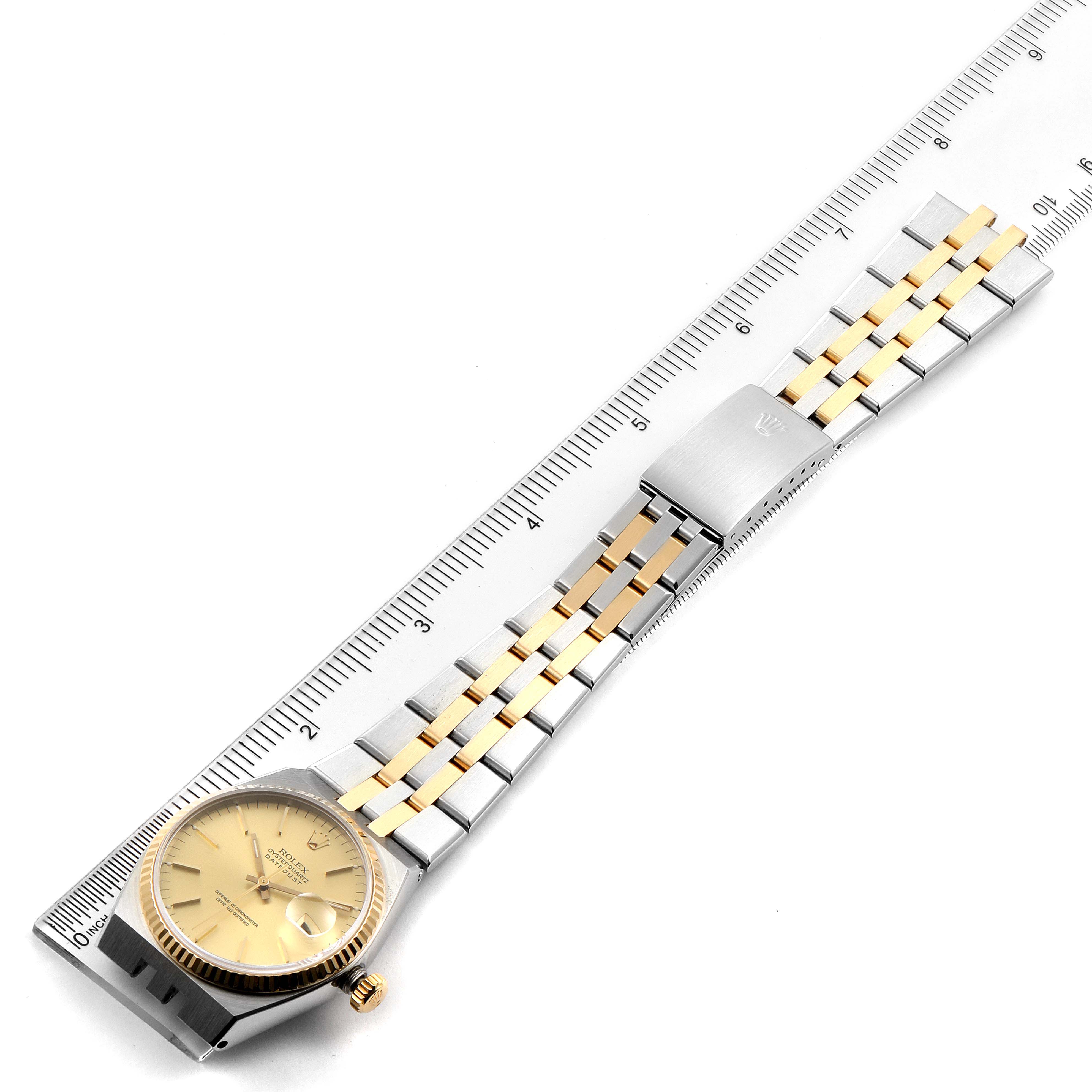 The image shows a Rolex Oysterquartz 17013 Men's Steel and Gold (two tone) Champagne Dial 17013 Men's Steel and Gold (two tone) Champagne Dial watch laid flat with an integrated stainless steel and gold bracelet next to a metric ruler.