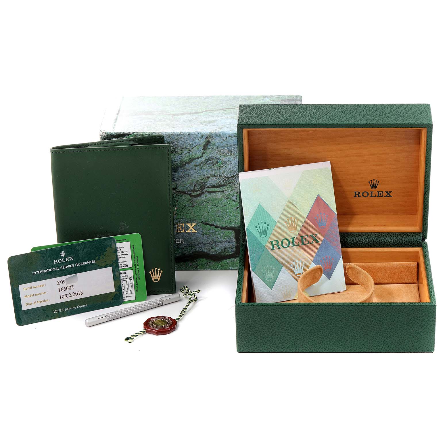 The image shows the accessories and packaging for a Rolex Sea-Dweller 16600 Men
s Stainless Steel Black Dial 16600 Men
s Stainless Steel Black Dial, including the box, booklet, guarantee card, and tool.