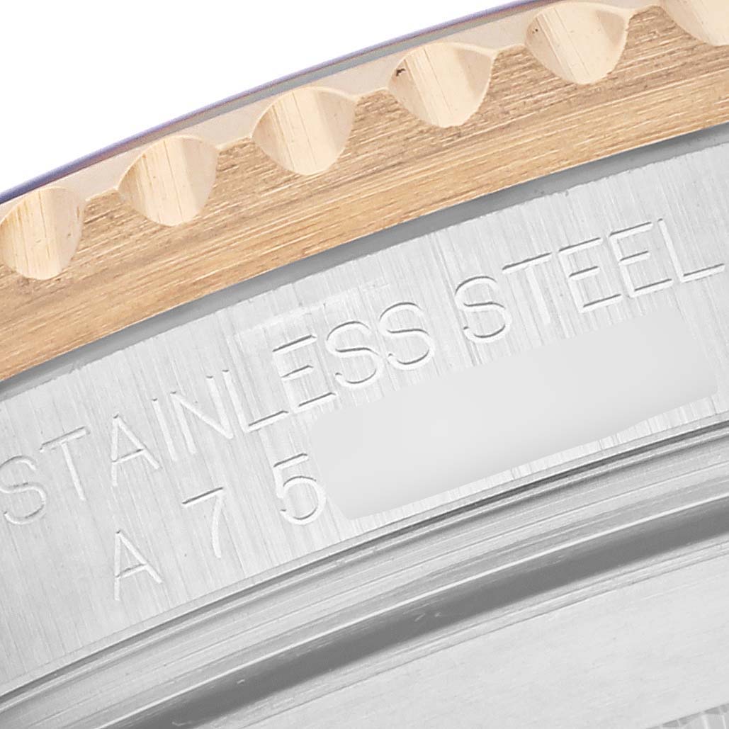 The image shows a close-up of the edge and engraved details on a Rolex Submariner 16613 Men's Steel and Gold (two tone) Blue Dial 16613 Men's Steel and Gold (two tone) Blue Dial watch case.