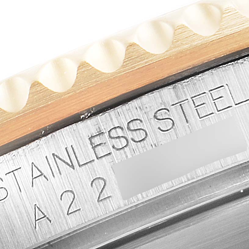 The image shows a close-up of the Rolex Submariner 16613 Men's Steel and Gold (two tone) Blue Dial 16613 Men's Steel and Gold (two tone) Blue Dial's bezel and the engraving on its stainless steel case.