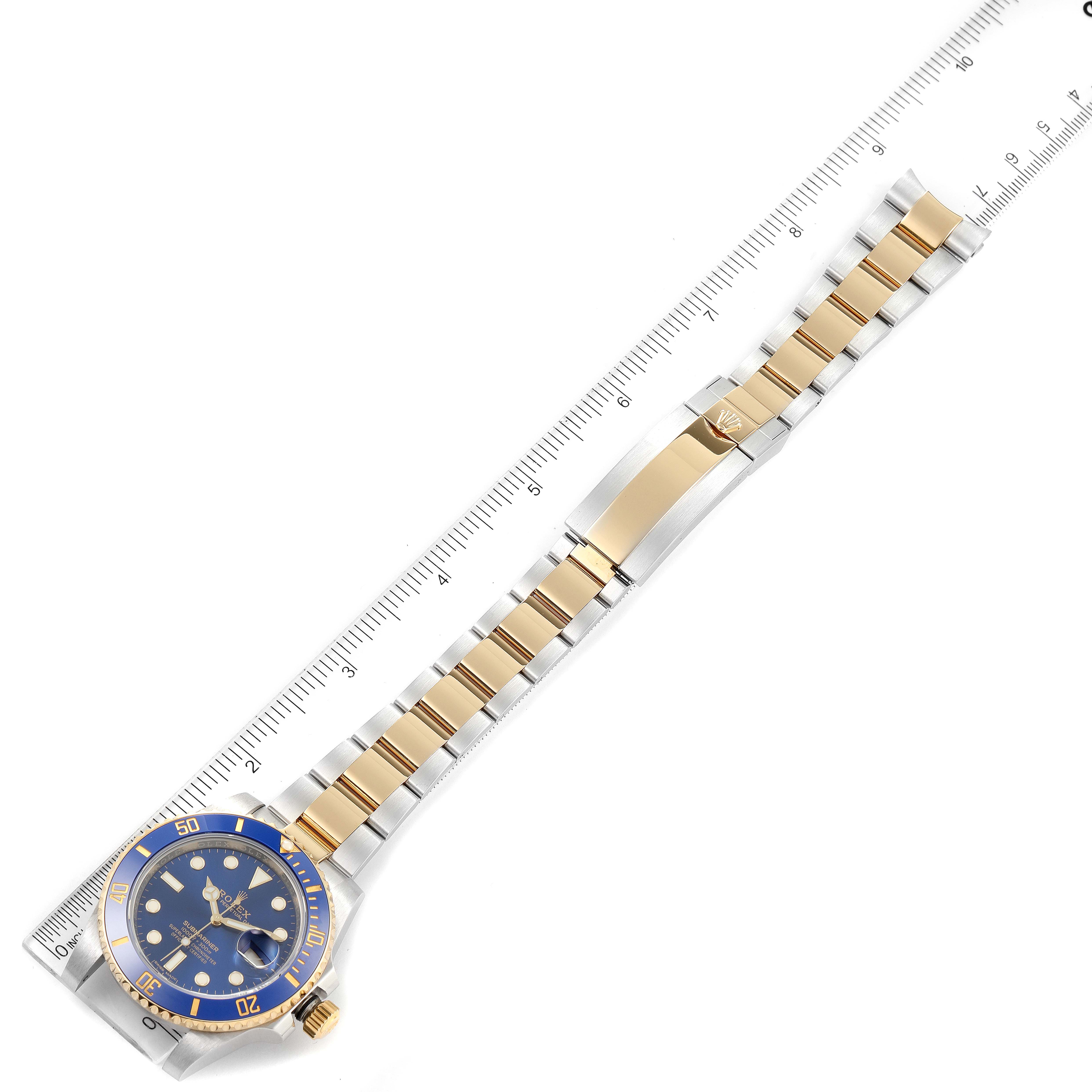 This image shows a top-down view of a Rolex Submariner 116613 Men
s Steel and Gold (two tone) Blue Dial 116613 Men
s Steel and Gold (two tone) Blue Dial watch with its full bracelet extended along a ruler for measurement.