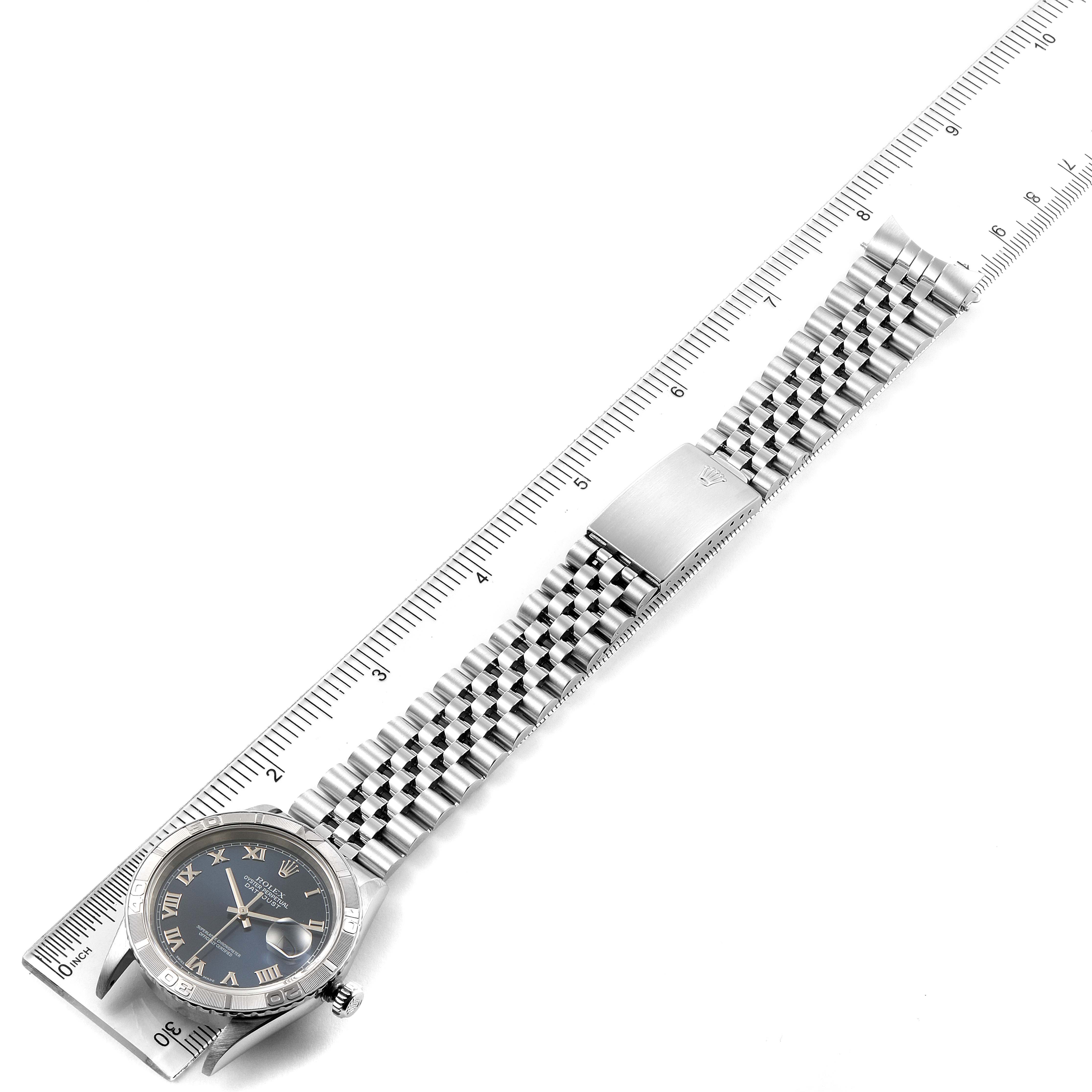 The image shows a Rolex Turn-o-Graph 16264 Men
s Stainless Steel Blue Dial 16264 Men
s Stainless Steel Blue Dial watch placed alongside a ruler, displaying the face, bracelet, and clasp from the top view.