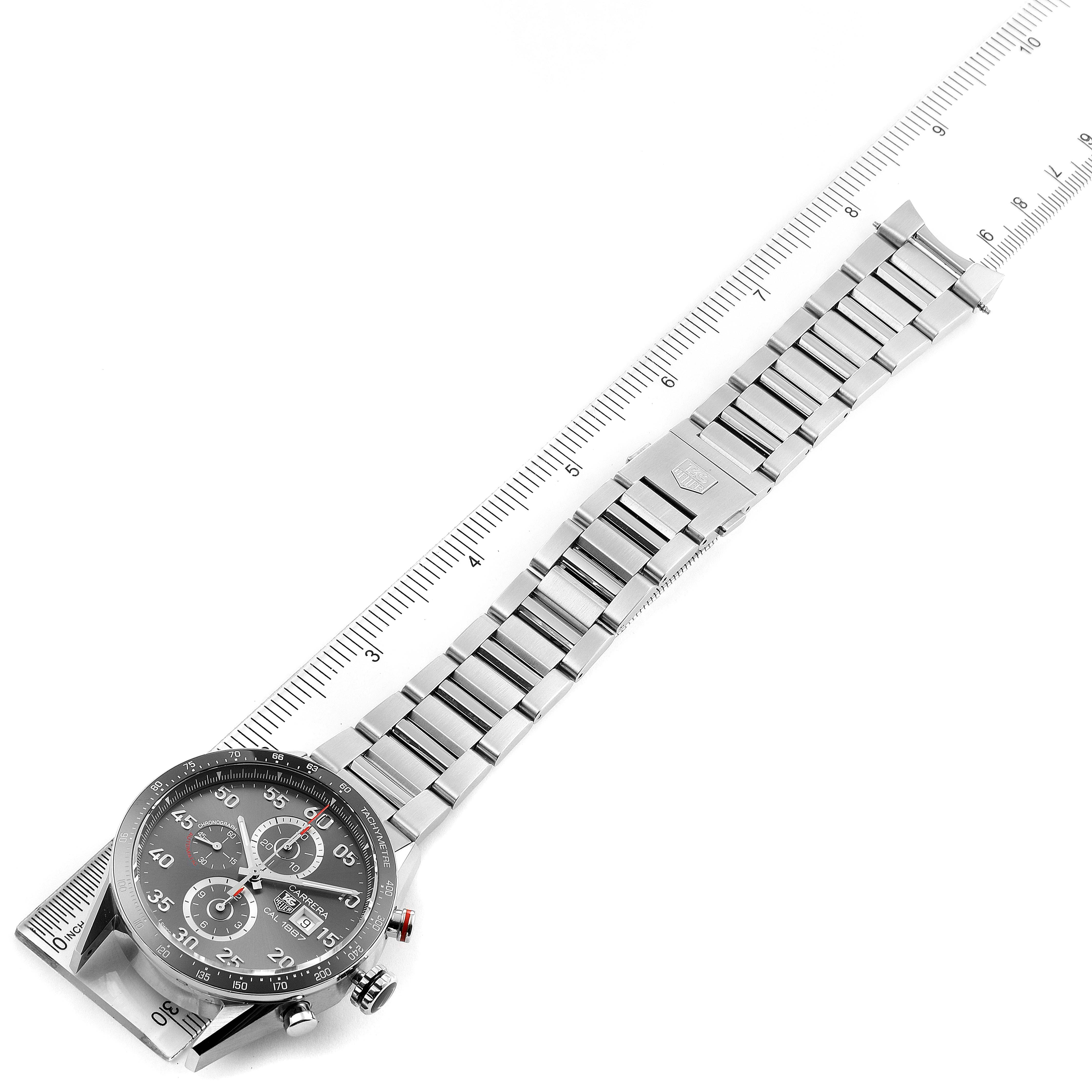 The image shows a full frontal view of the Tag Heuer Carrera CAR2A11.BA0799 Men's Stainless Steel Grey Dial CAR2A11.BA0799 Men's Stainless Steel Grey Dial watch, including its dial and stainless steel bracelet aligned with a ruler.