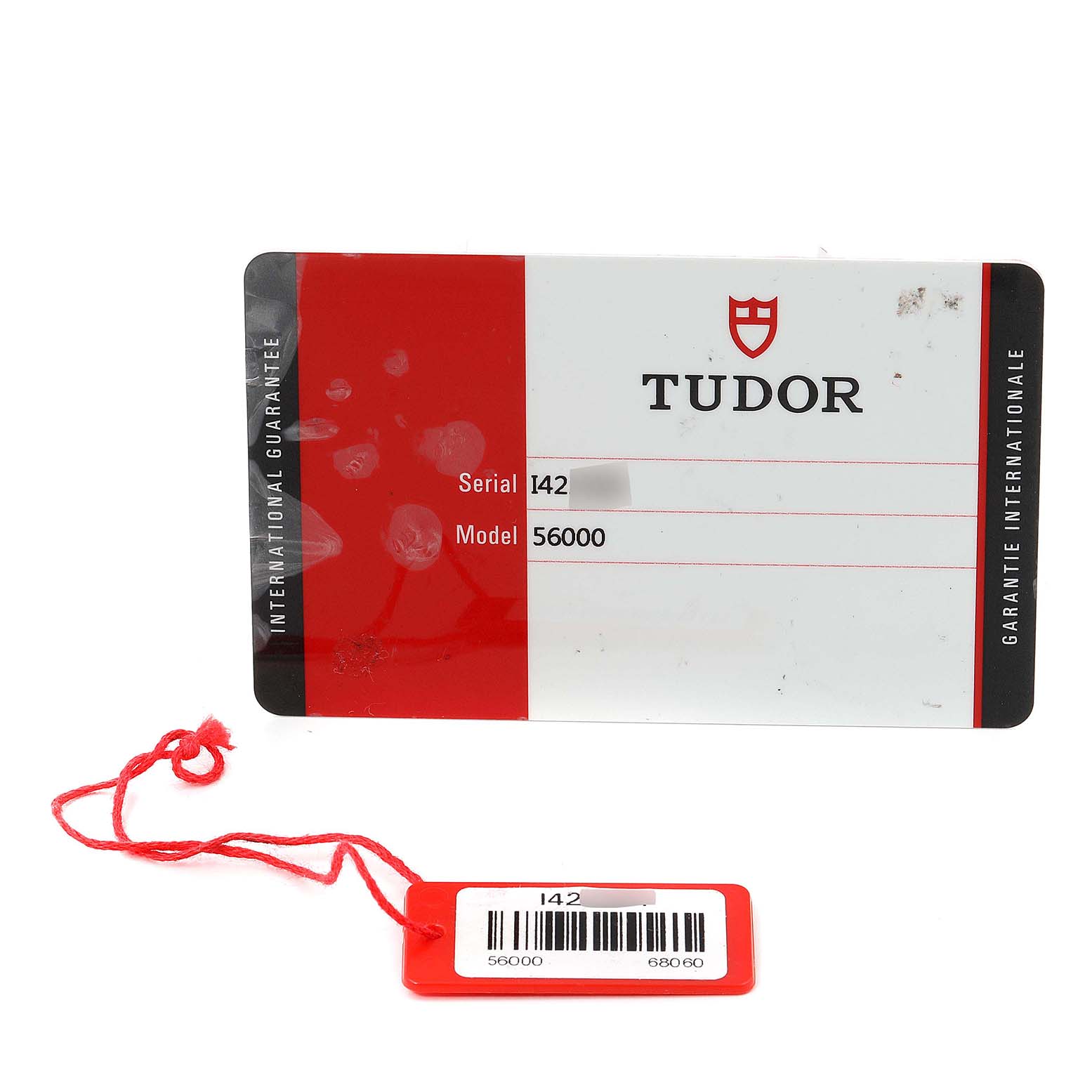The image shows the warranty card and tag for a Tudor Glamour M56000-0008 Men's Stainless Steel Silver Dial M56000-0008 Men's Stainless Steel Silver Dial model watch, providing the serial number and model number.