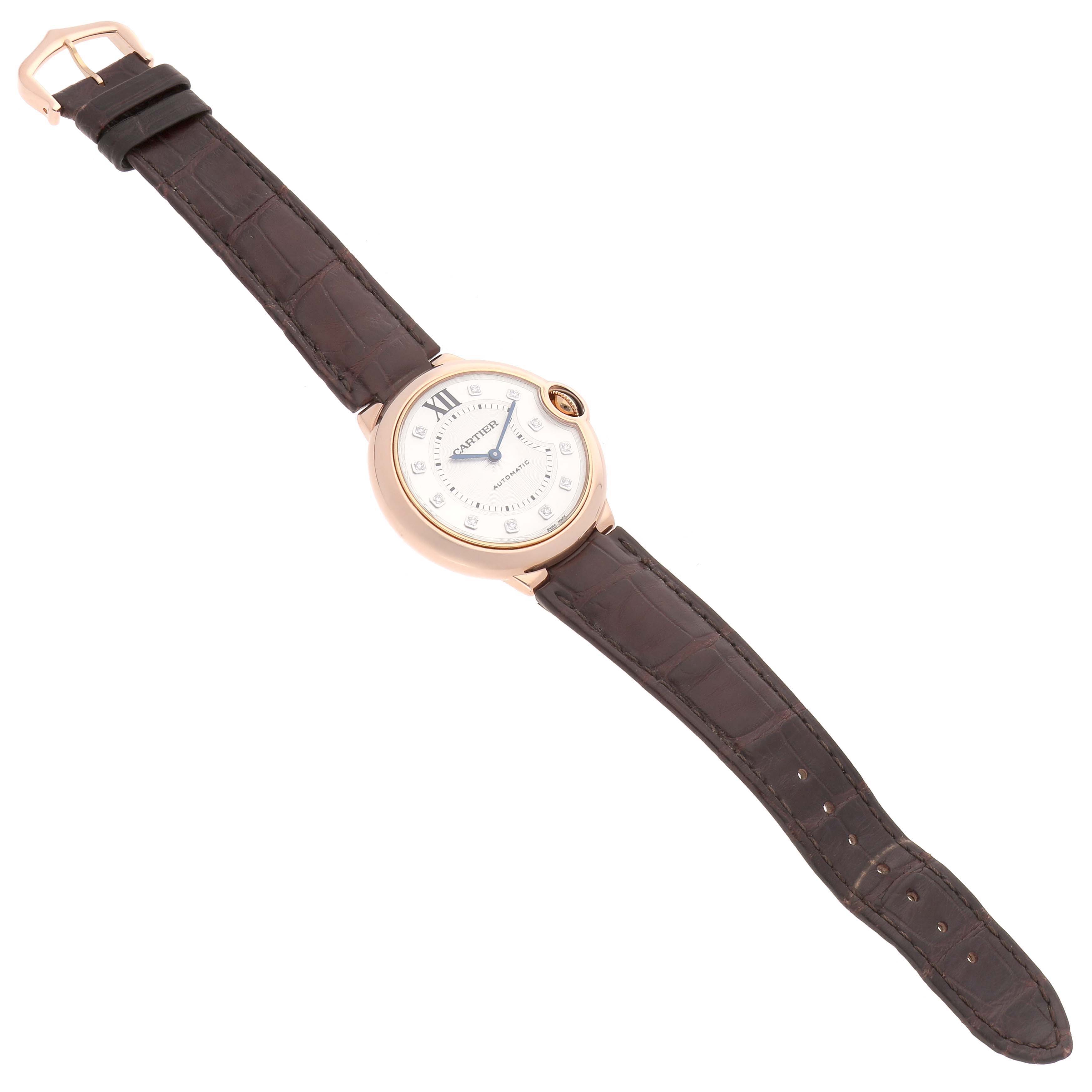 The Cartier Ballon Bleu WJBB0010 Women's Rose Gold Silver Dial watch is angled to show its face, case, and leather strap with the clasp visible.