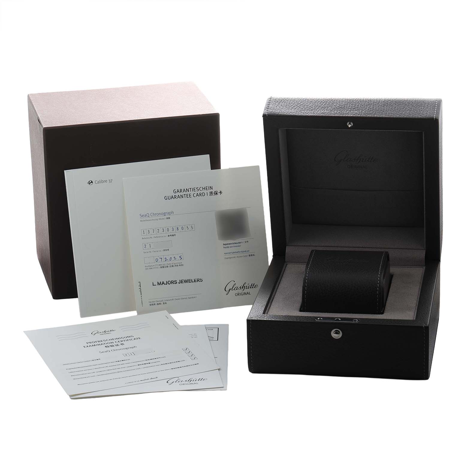 The image shows the Glashütte Original model box, guarantee card, and paperwork from a front angle.