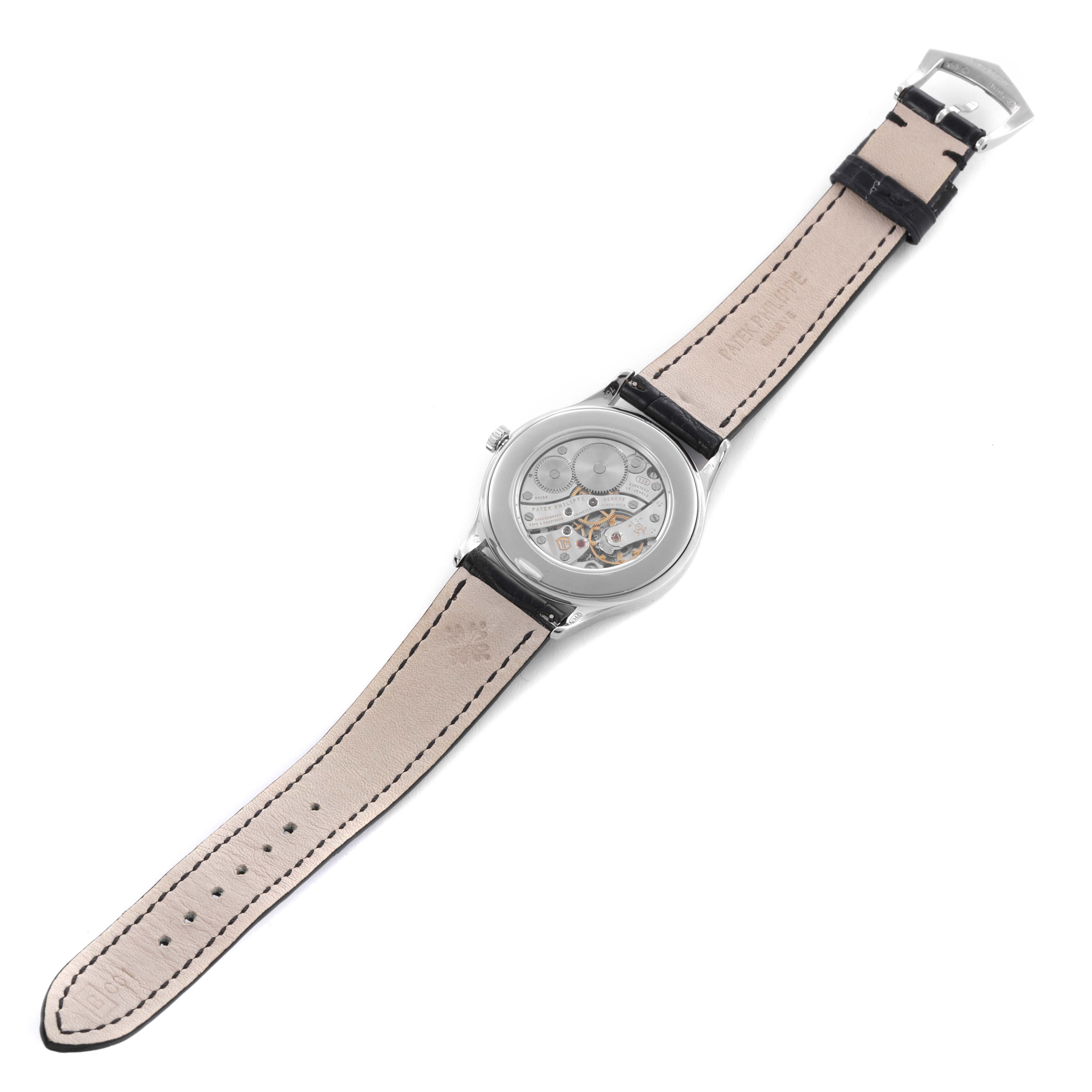 The image shows the back of a Patek Philippe Calatrava 4897G-010 Women's White Gold Grey Dial 4897G-010 Women's White Gold Grey Dial watch, highlighting its exposed mechanical movement and leather strap.
