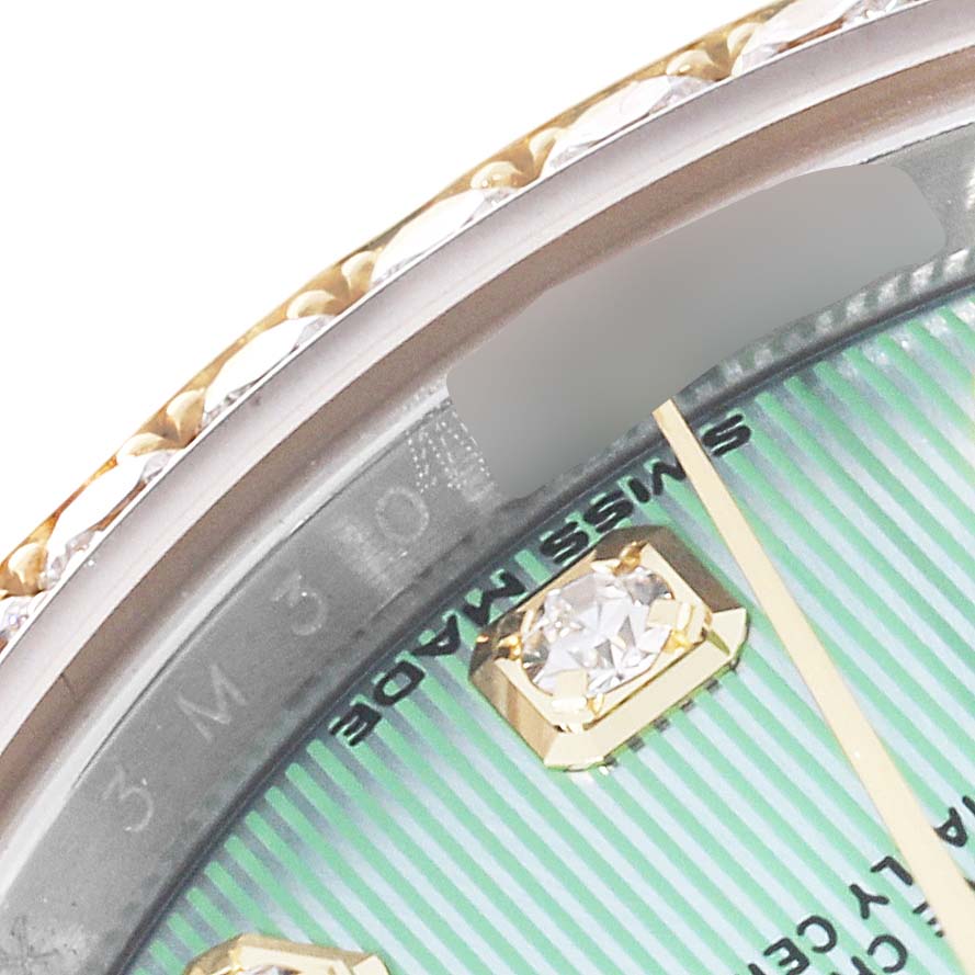 This close-up image of a Rolex Datejust 279383 Women's Steel and Gold (two tone) Green Dial 279383 Women's Steel and Gold (two tone) Green Dial watch shows the edge of the bezel, part of the dial, and a diamond hour marker.