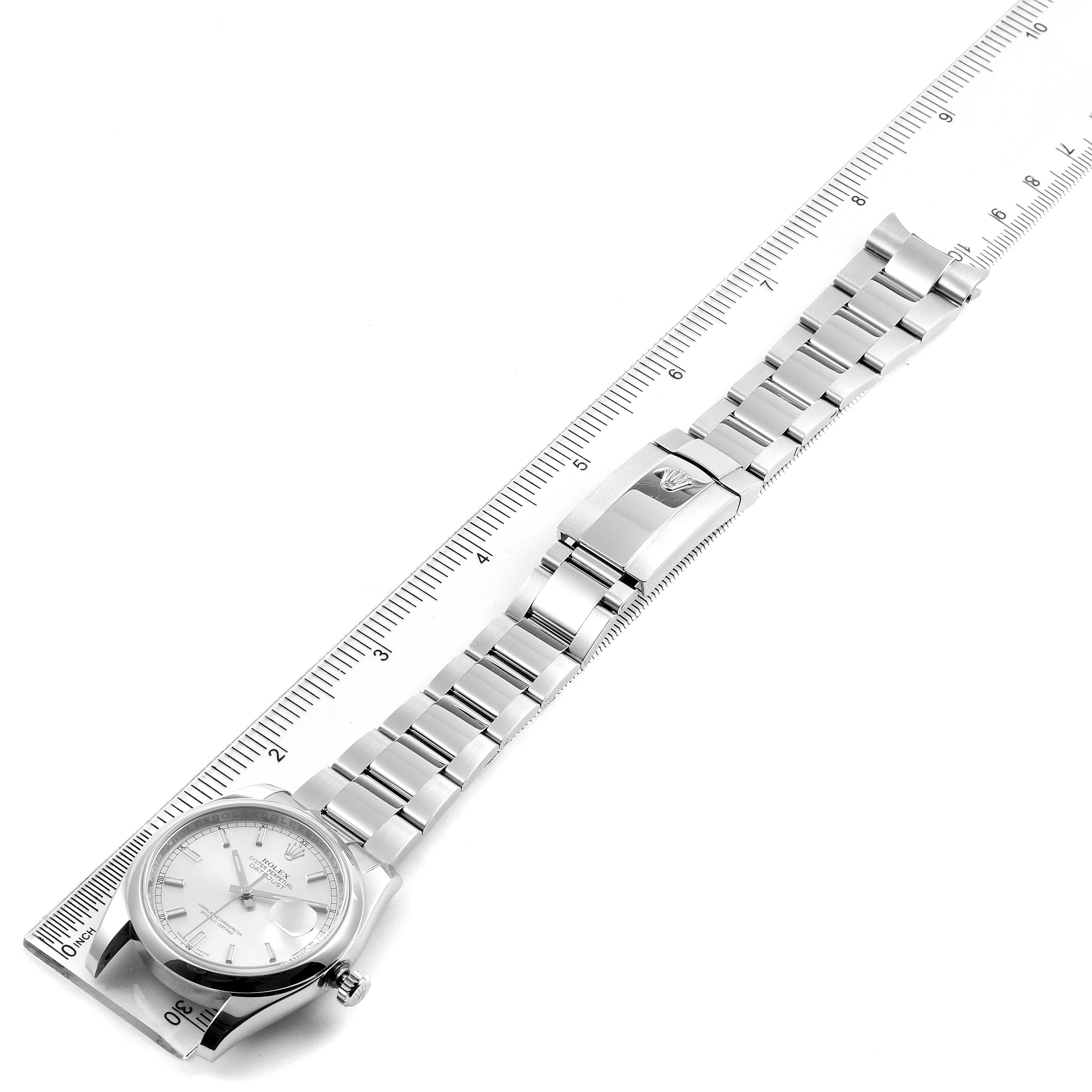 The image shows a top-down view of a Rolex Datejust 116200 Men's Stainless Steel Silver Dial 116200 Men's Stainless Steel Silver Dial watch, displaying the face, bracelet, and clasp next to a measuring ruler.
