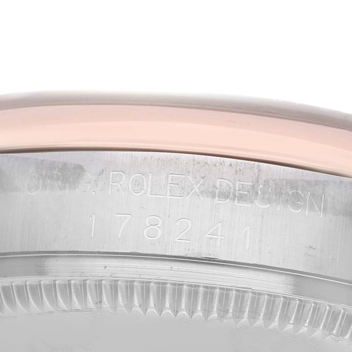 The image shows a close-up side angle of the bezel and engraved case of the Rolex Mid-Size 178241 Women's Steel and Gold (two tone) White Dial model.
