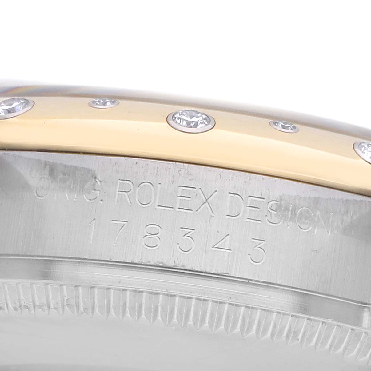 The image shows a close-up of the side of a Rolex Mid-Size 178343 Women's Steel and Gold (two tone) Champagne Dial watch, highlighting the engraved bezel and diamonds.