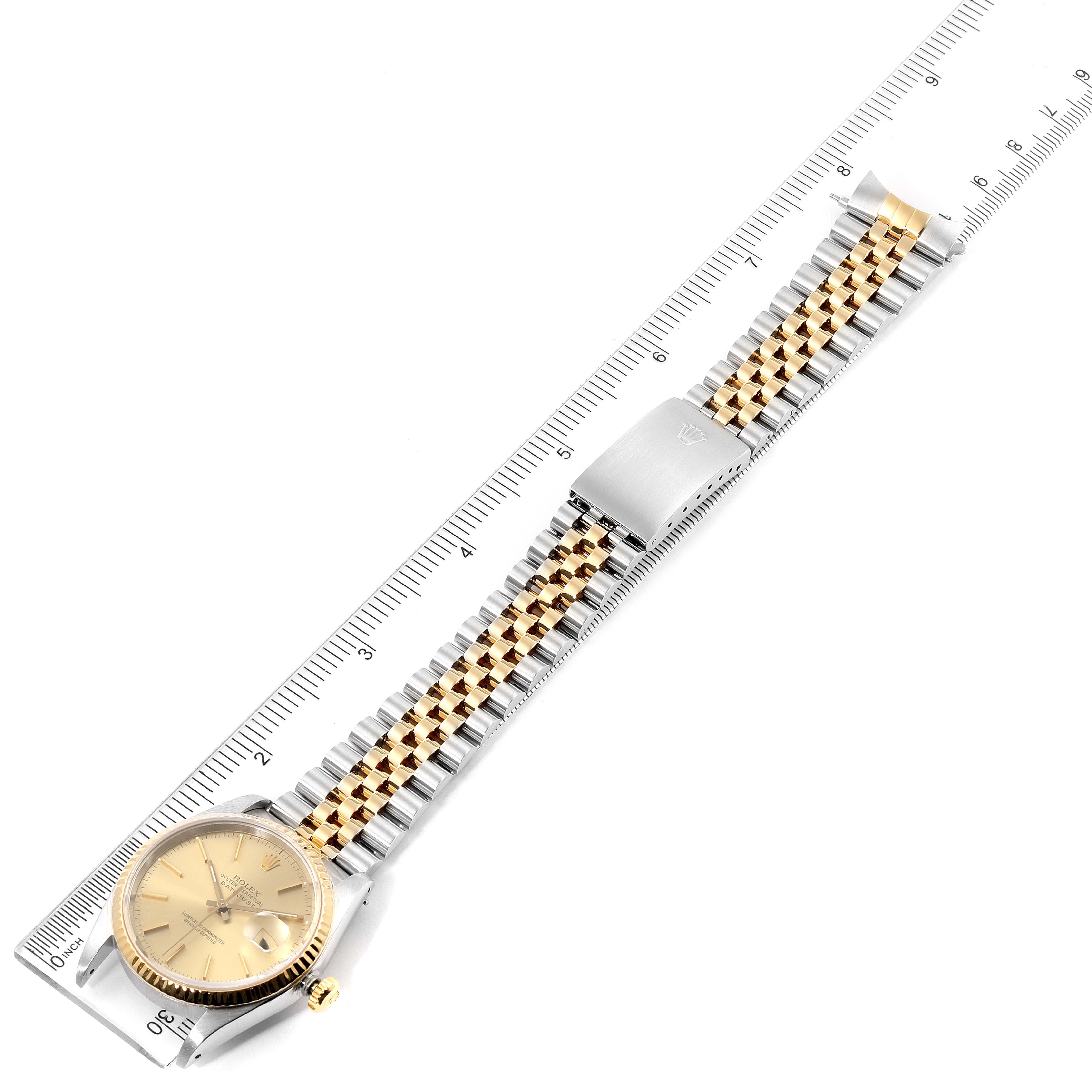 The Rolex Datejust 16233 Men's Steel and Gold (two tone) Champagne Dial 16233 Men's Steel and Gold (two tone) Champagne Dial watch is shown flat from above, displaying its dial, bracelet, and clasp with a ruler for scale.