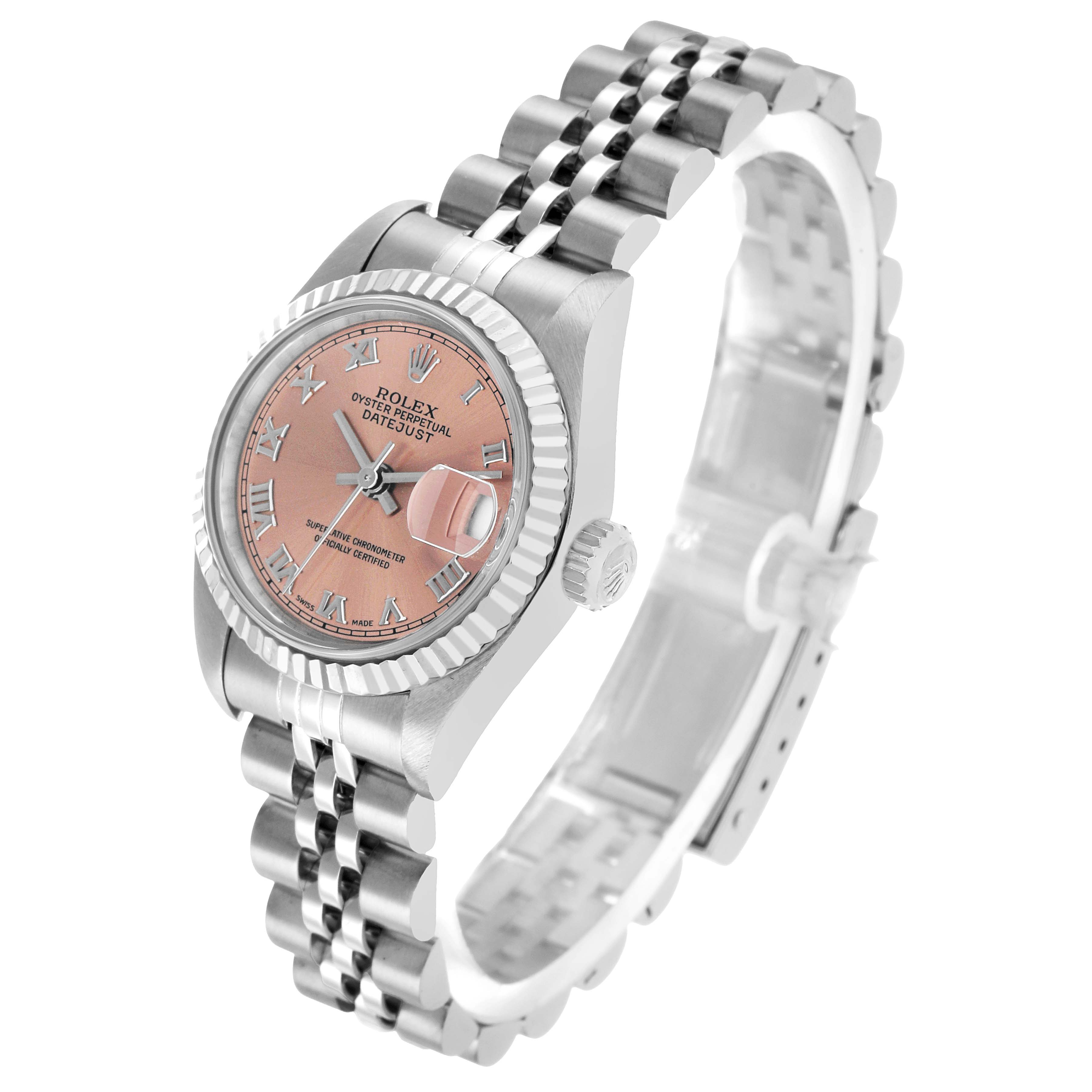 The Rolex Datejust 79174 Women's Stainless Steel Pink Dial watch is shown from an angled perspective, displaying the pink dial, fluted bezel, and Jubilee bracelet.