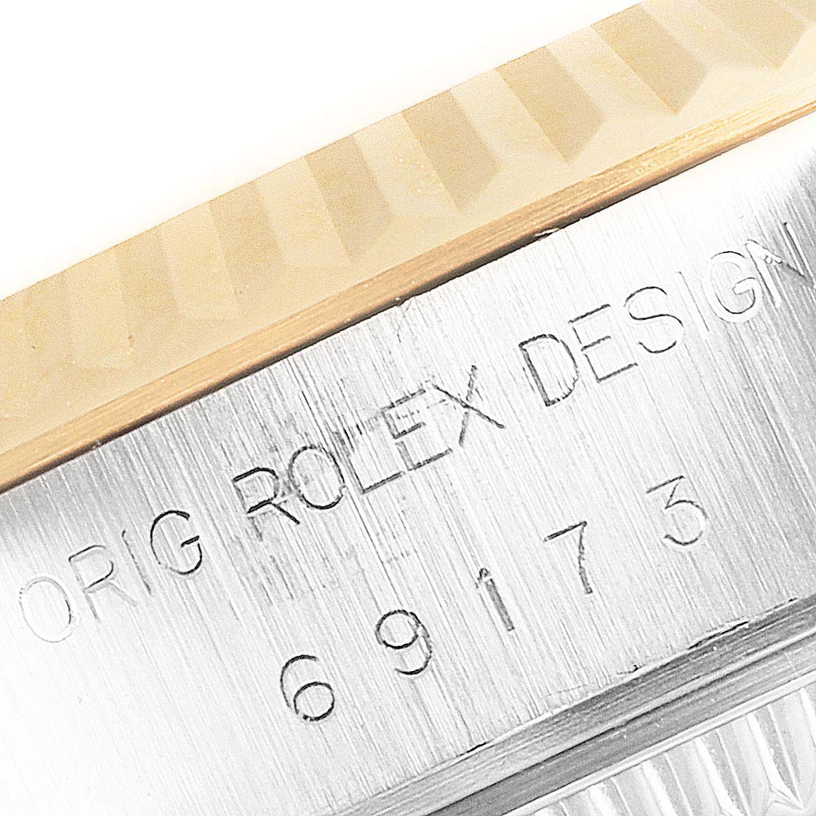 This close-up image of a Rolex Datejust 69173 Women's Steel and Gold (two tone) Silver Dial 69173 Women's Steel and Gold (two tone) Silver Dial watch shows the bezel and engraved model number on the side of the case.