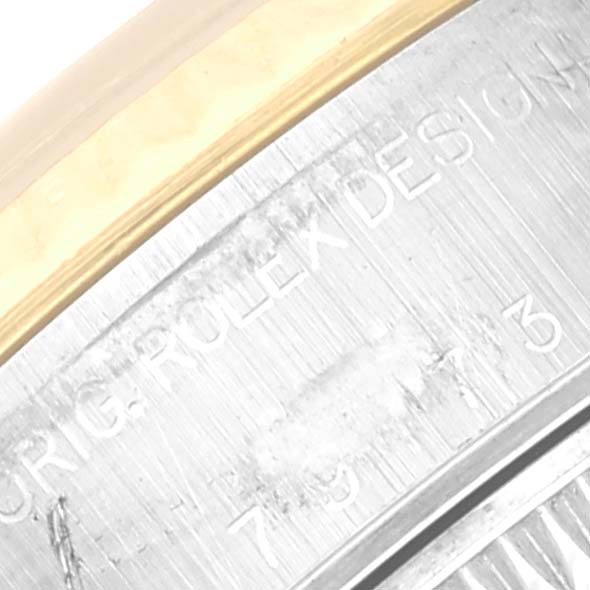 This image shows an angled close-up of the case back edge of the Rolex Datejust 79173G Women's Steel and Gold (two tone) Silver Dial 79173G Women's Steel and Gold (two tone) Silver Dial, displaying part of the engraved text.