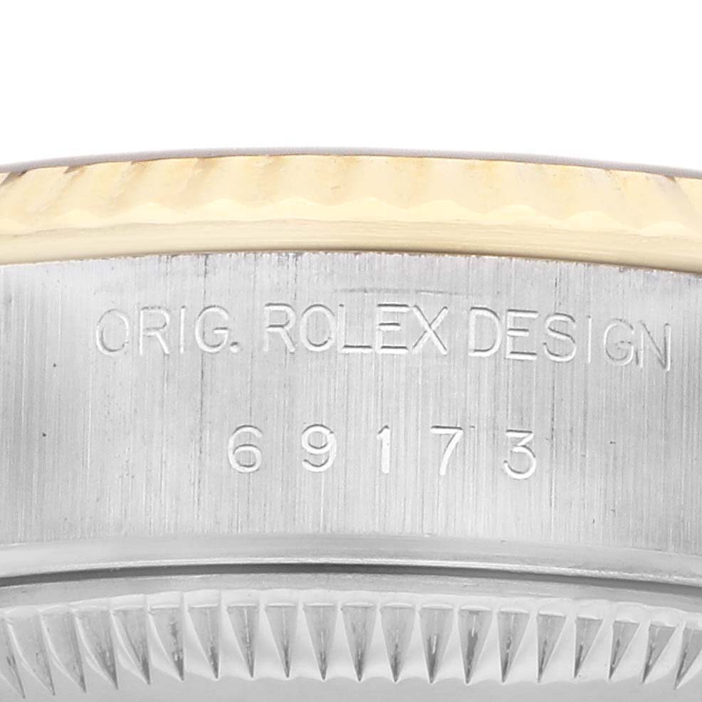 The image shows a close-up of the side of a Rolex Datejust 69173 Women's Steel and Gold (two tone) Champagne Dial, highlighting the bezel and serial engraving.