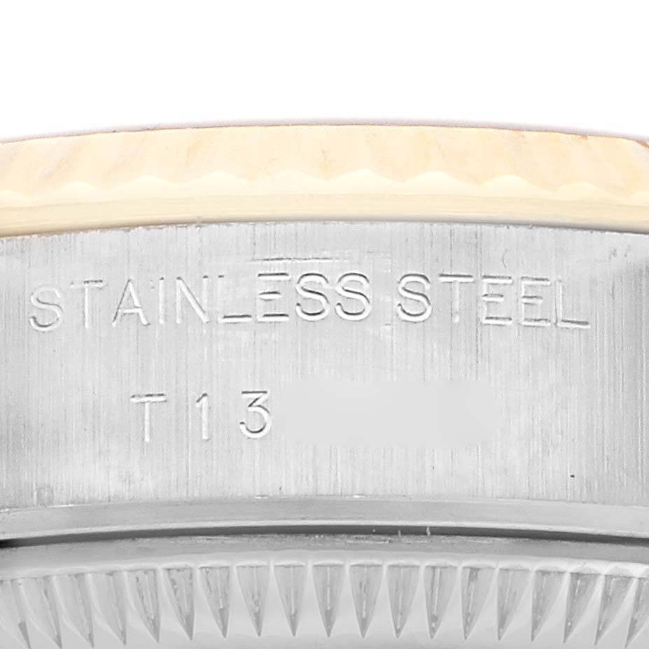 The image shows the side view of a Rolex Datejust 69173 Women's Steel and Gold (two tone) Champagne Dial, focusing on the stainless steel case and bezel engraving.