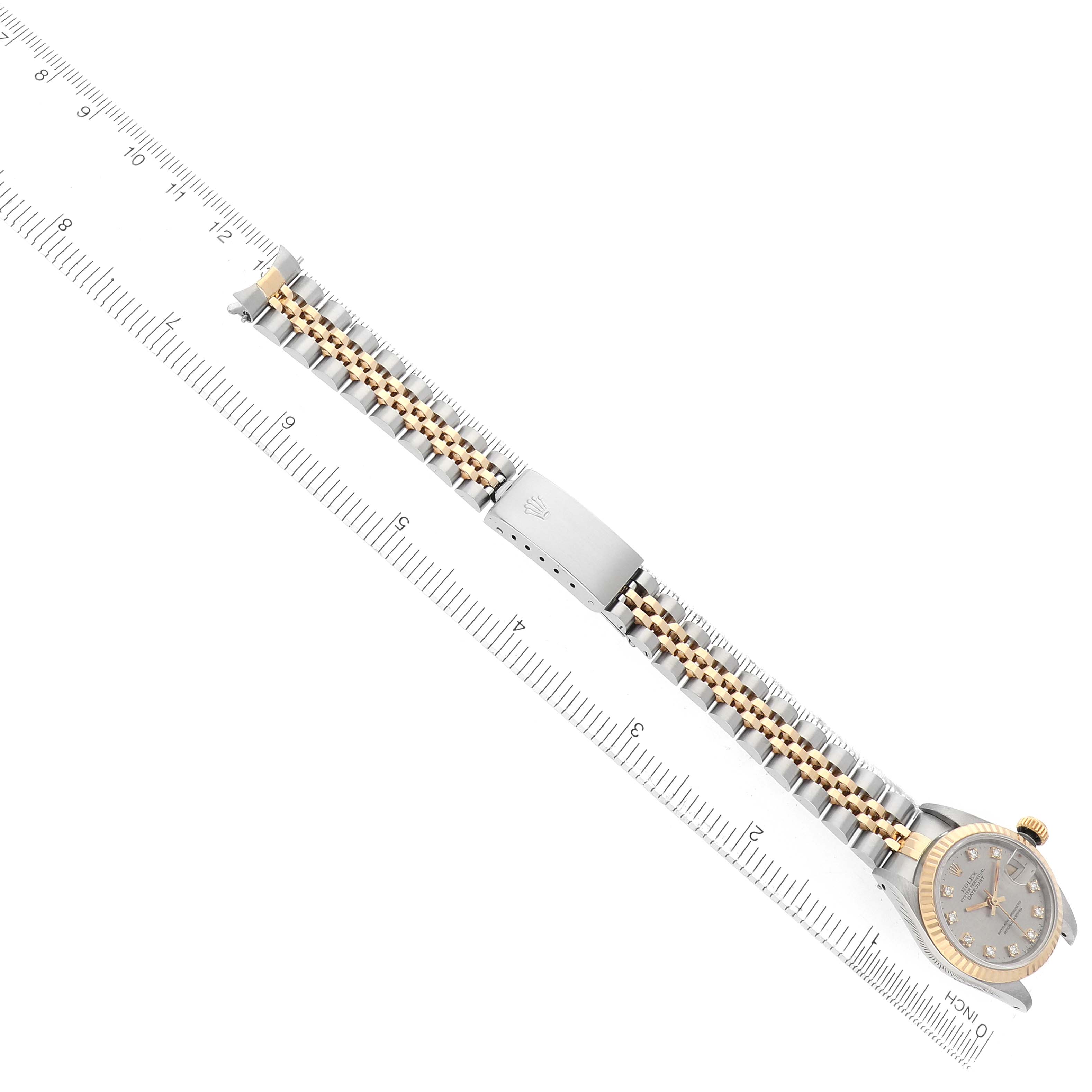 The image shows a Rolex Datejust 69173 Women's Steel and Gold (two tone) Silver Dial watch at an angle, displaying the face, bracelet, and clasp, with a ruler underneath for scale.