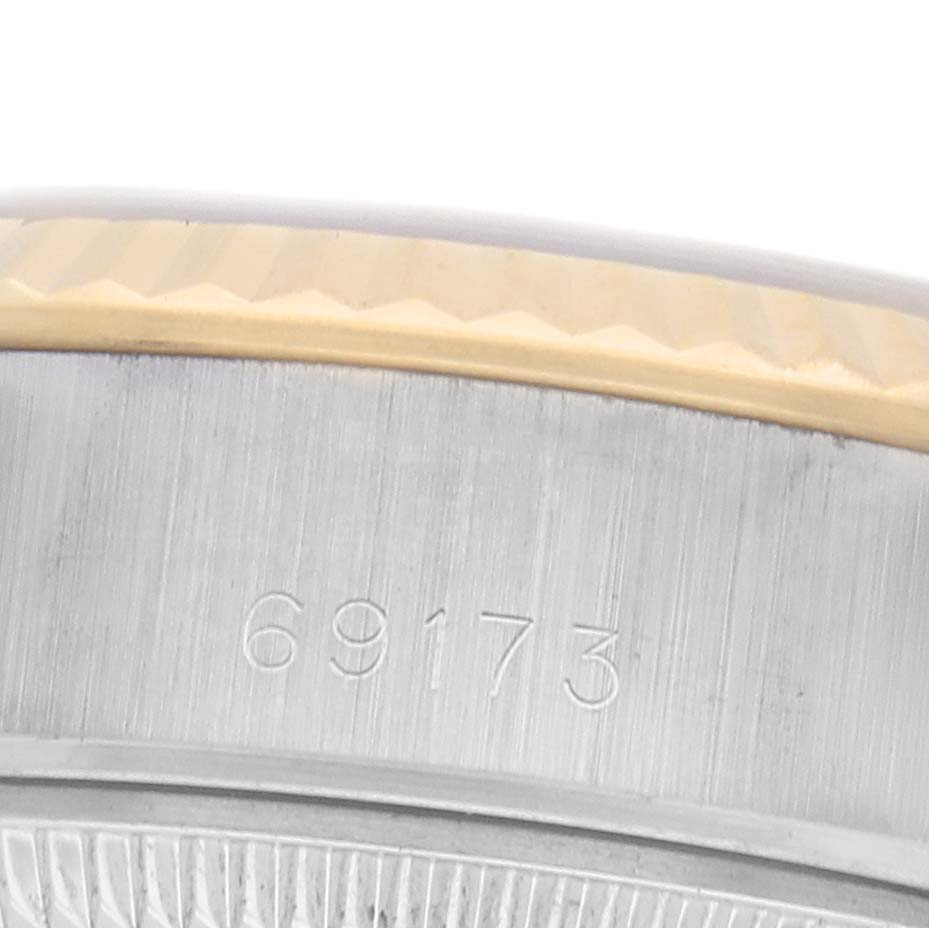 The image shows a close-up of the bezel and engraved serial number of a Rolex Datejust 69173 Women's Steel and Gold (two tone) Silver Dial watch.