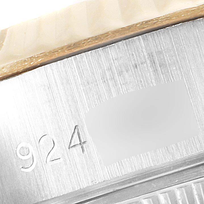 This close-up image of the Rolex Datejust 69173 Women's Steel and Gold (two tone) White Dial 69173 Women's Steel and Gold (two tone) White Dial watch shows part of the metal engraving on the watch casing.