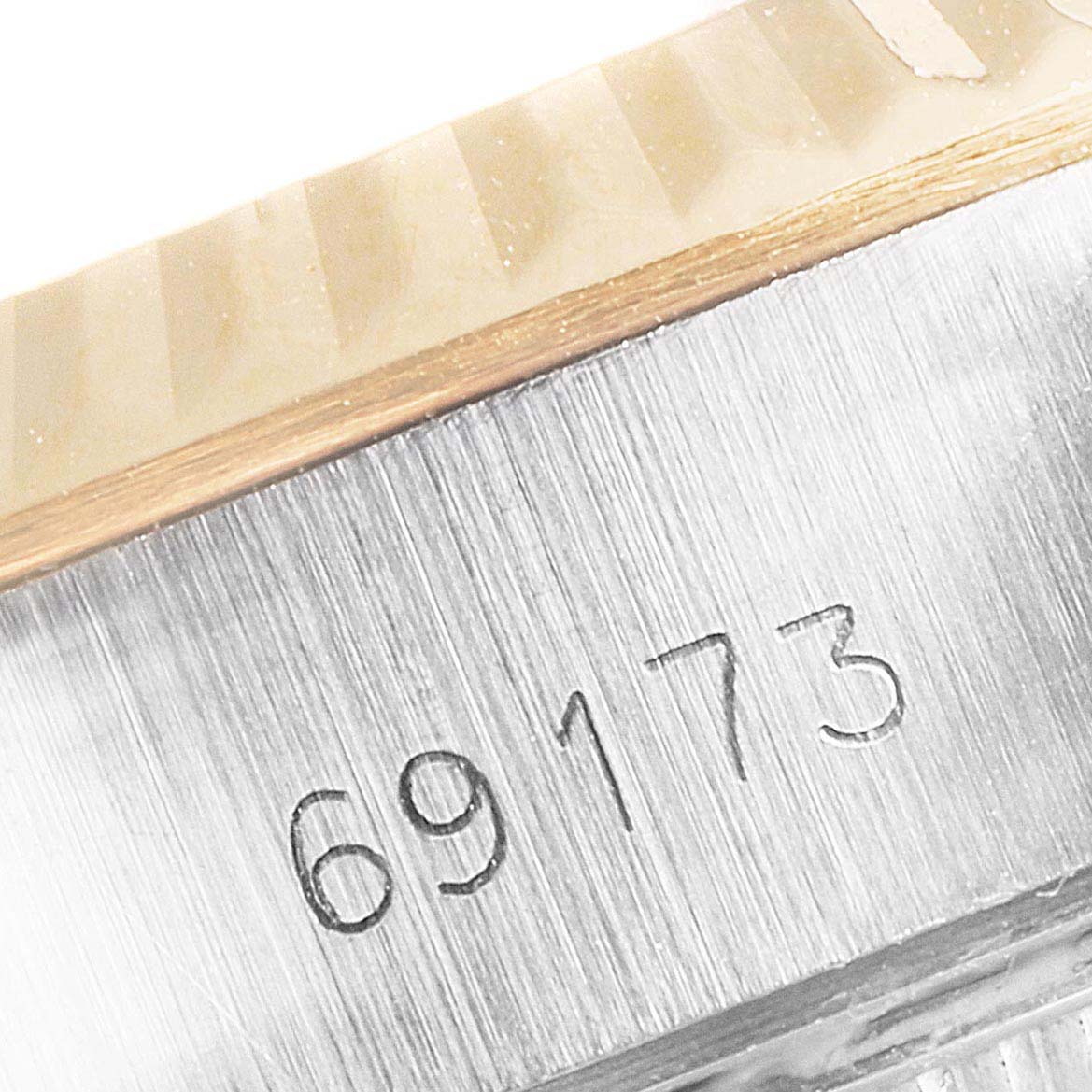 This close-up image shows the reference number and part of the fluted bezel of a Rolex Datejust 69173 Women's Steel and Gold (two tone) White Dial 69173 Women's Steel and Gold (two tone) White Dial model.