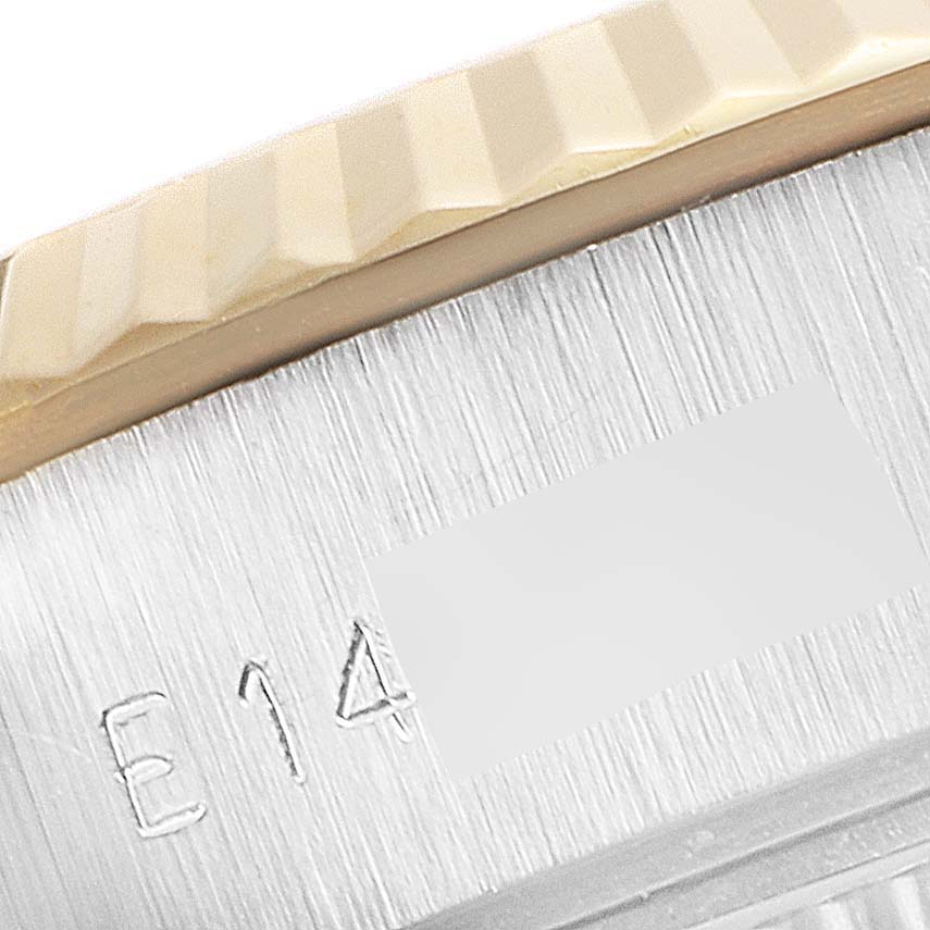 This close-up of the Rolex Datejust 69173 Women's Steel and Gold (two tone) White Dial 69173 Women's Steel and Gold (two tone) White Dial watch shows the edge of the fluted bezel and a part of the serial number engraving.