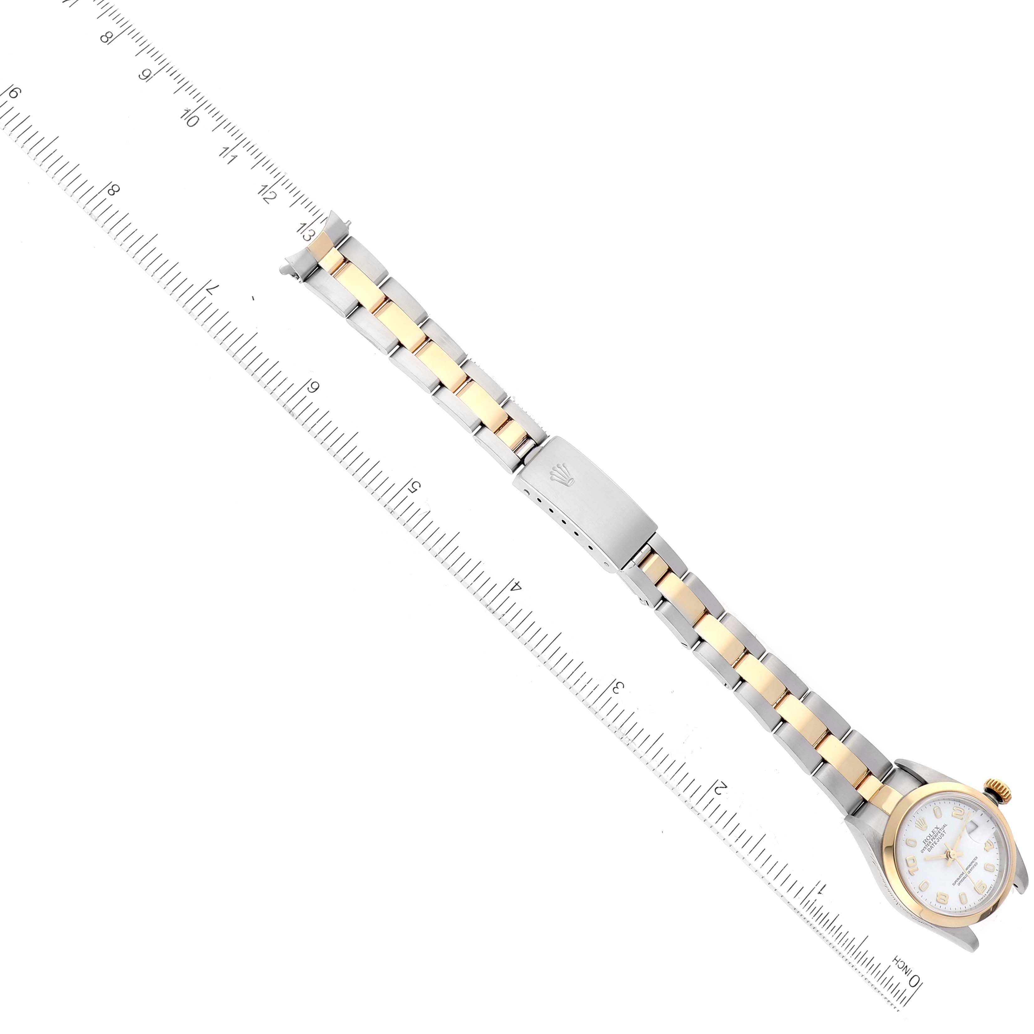 The Rolex Datejust 79163 Women
s Steel and Gold (two tone) White Dial 79163 Women
s Steel and Gold (two tone) White Dial watch is shown from a top-down angle, displaying the full bracelet and face alongside a ruler.