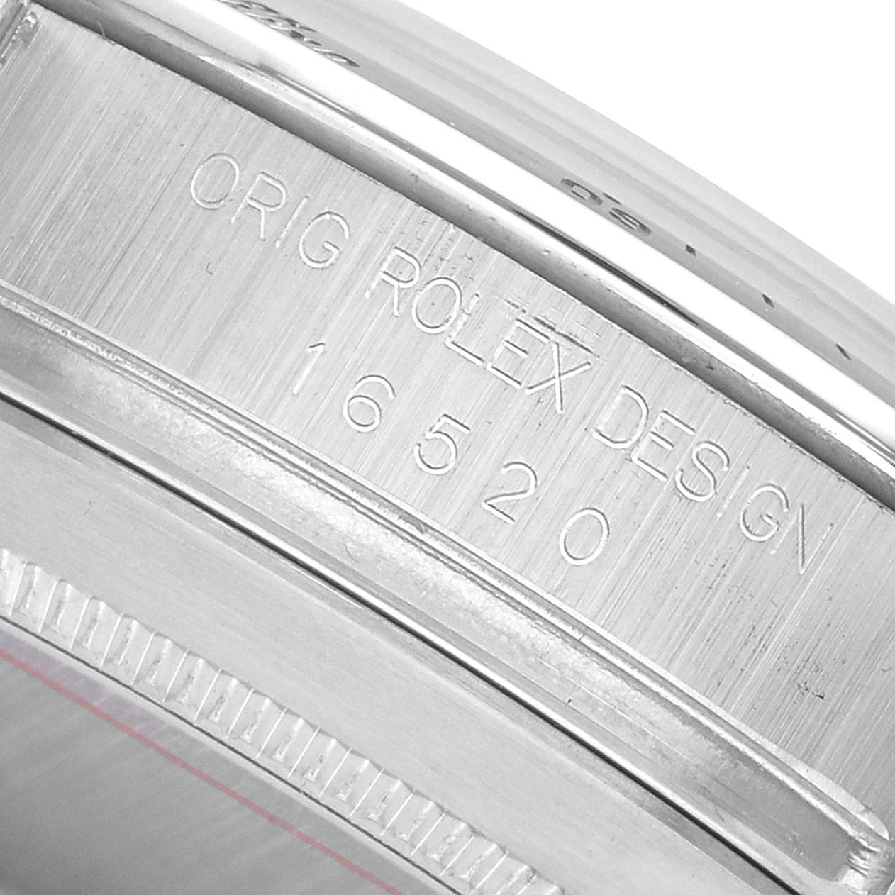 The image shows the side of a Rolex Daytona 16520 Men's Stainless Steel White Dial, highlighting the engraved model number and brand name on the watch case.