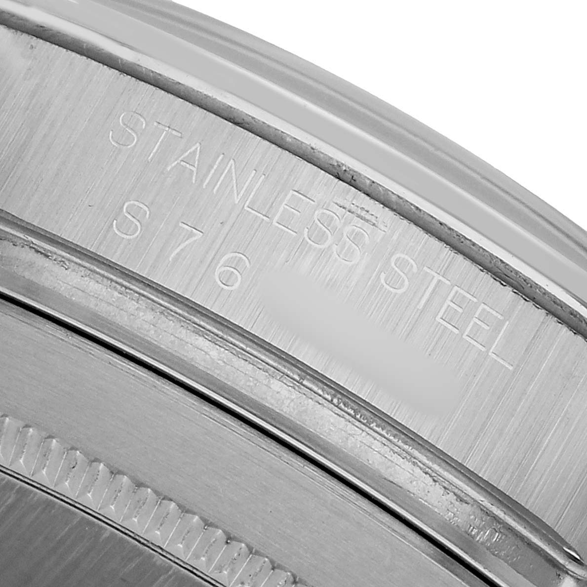 The image shows a close-up of the engraved inner rim of a Rolex Daytona 16520 Men's Stainless Steel White Dial, indicating "Stainless Steel."