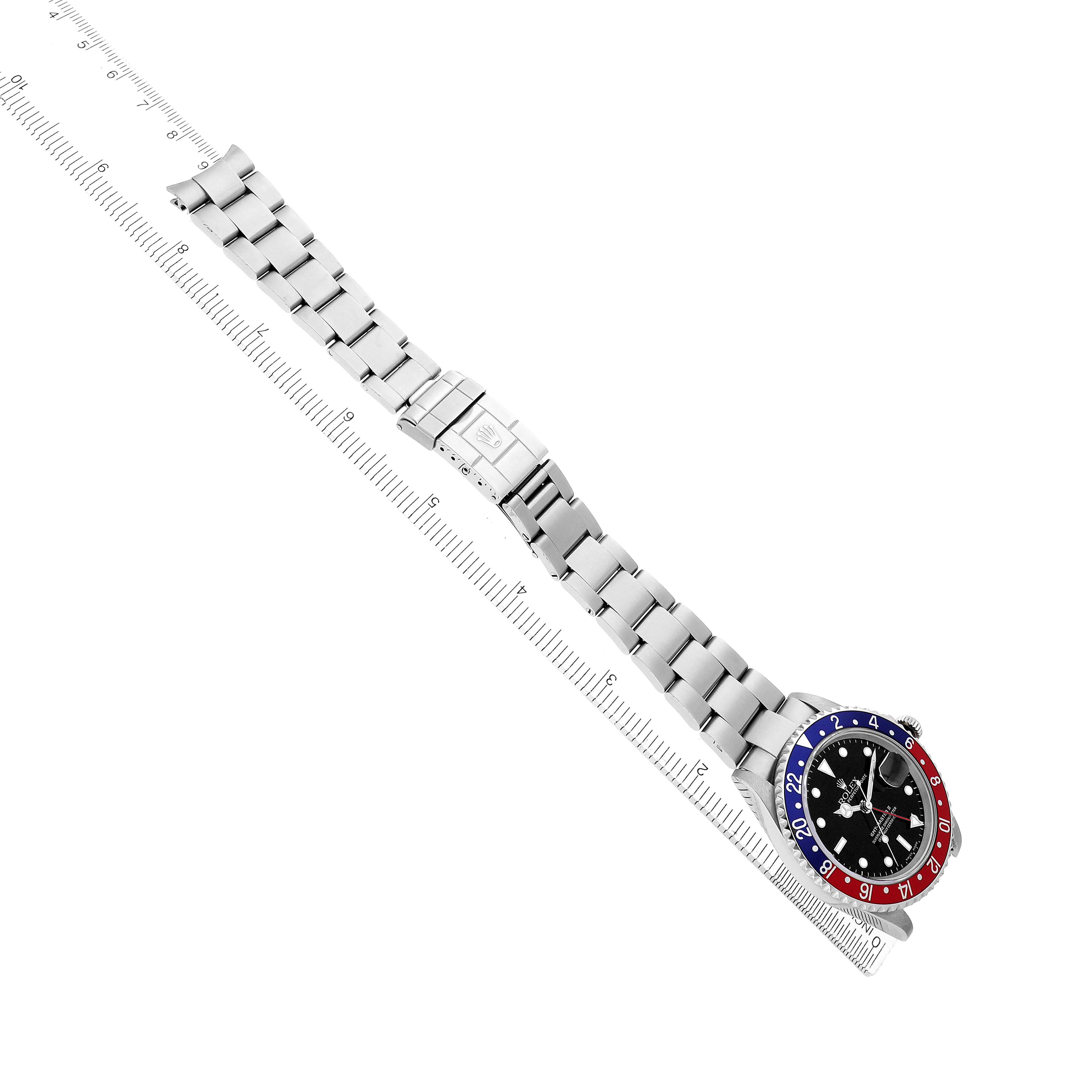 The Rolex GMT-Master 16710 Men's Stainless Steel Black Dial watch is shown from a top view, displaying the bracelet, clasp, and bezel on a diagonal ruler.