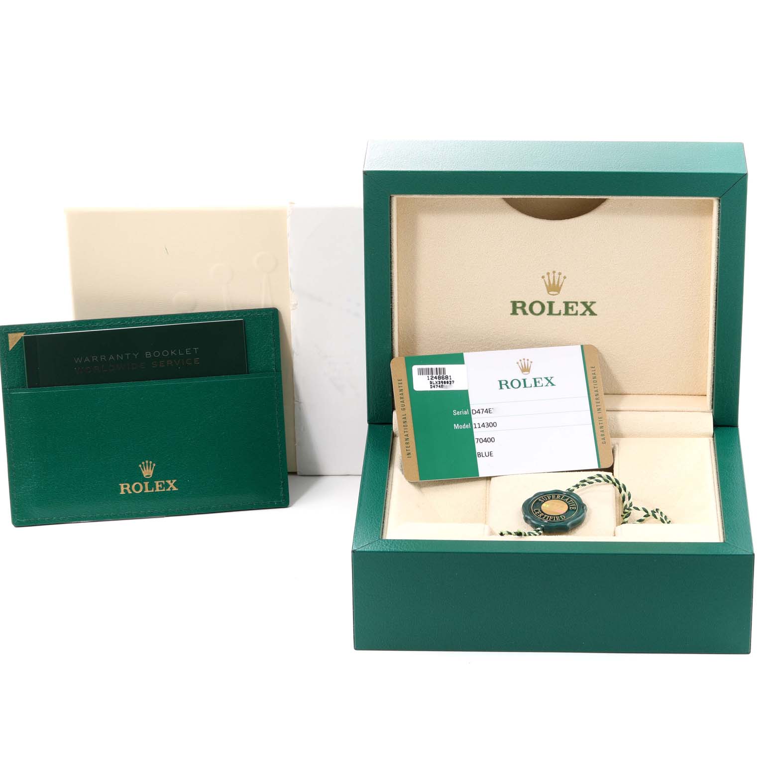 The image shows a Rolex Oyster Perpetual 114300 Men
s Stainless Steel Blue Dial 114300 Men
s Stainless Steel Blue Dial watch box, warranty booklet, and serial/model tag from a front angle.