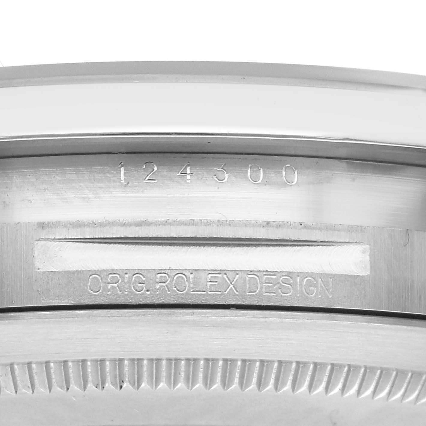 The image shows the side view of a Rolex Oyster Perpetual 124300 Men's Stainless Steel Blue Dial 124300 Men's Stainless Steel Blue Dial watch case with engravings of the model number and design.