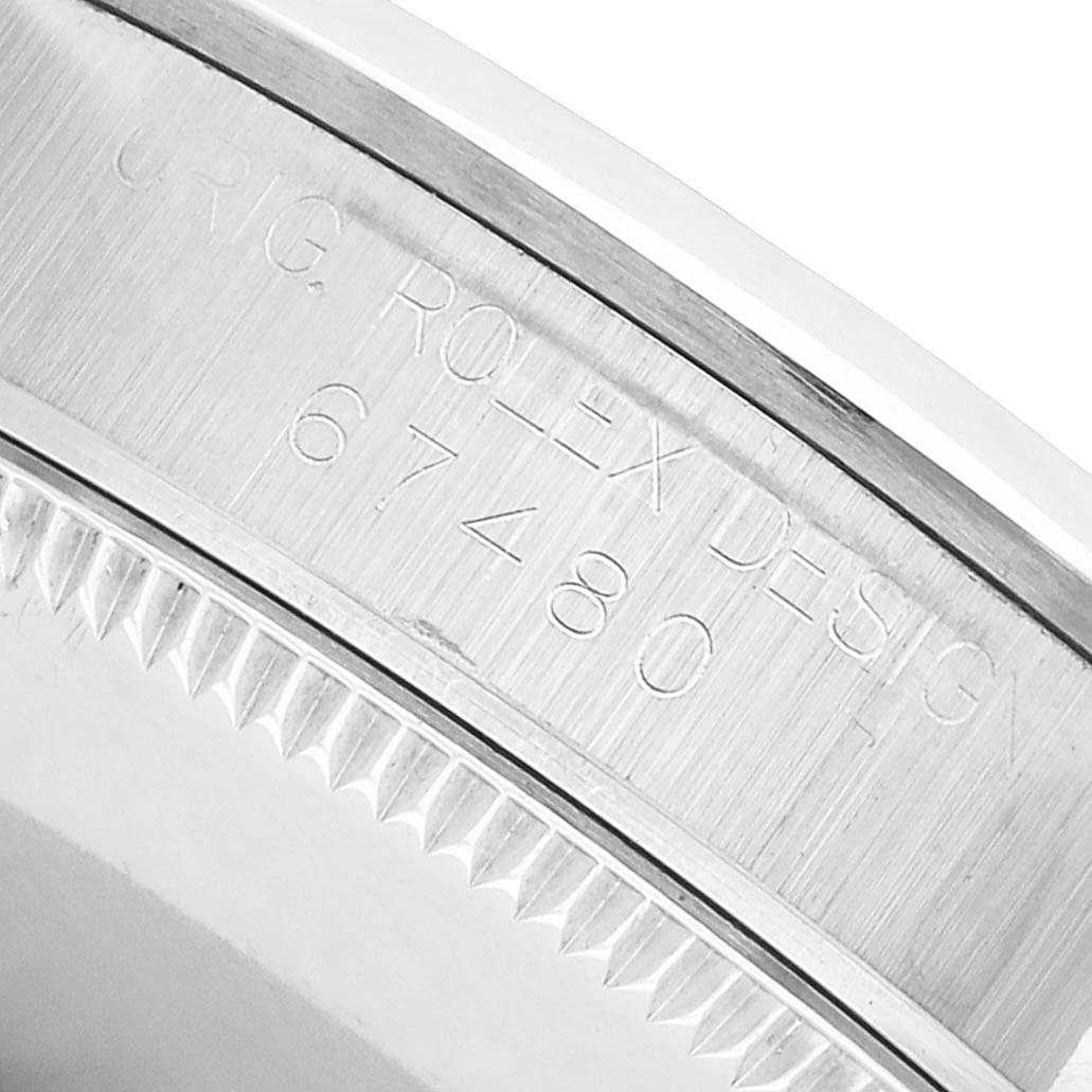 The image shows the case side of a Rolex Mid-Size 67480 Women's Stainless Steel Pink Dial watch, displaying its engraved model number on the metal surface.
