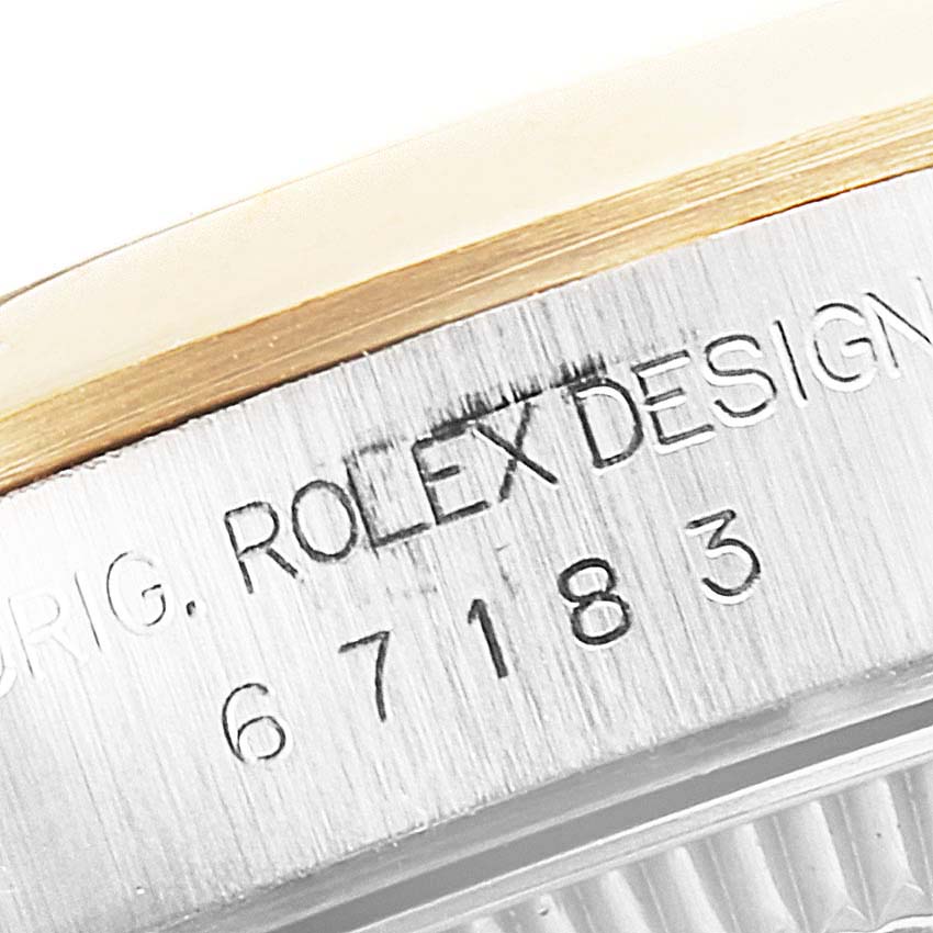 This close-up angle shows the side of the Rolex Oyster Perpetual 76193 Women's Steel and Gold (two tone) Grey Dial 76193 Women's Steel and Gold (two tone) Grey Dial watch with part of the bezel and engraved model details.