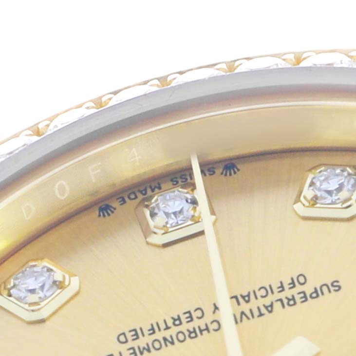 This close-up shows the Rolex President 279138 Women's Yellow Gold Champagne Dial model's diamond hour markers, part of the dial, and the edge of the bezel at an angle.