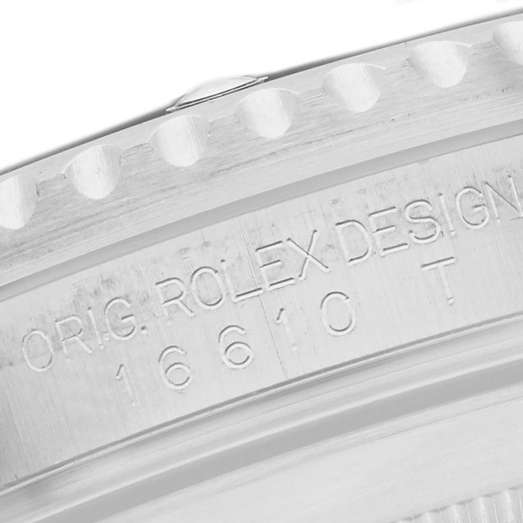 The image shows a close-up of the engraved case edge of a Rolex Submariner 16610 Men's Stainless Steel Black Dial, highlighting the model number and design details.