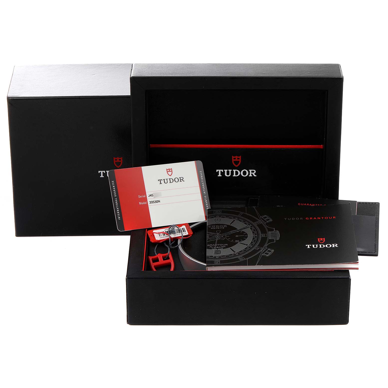 The image shows packaging and accessories for the Tudor Grantour 20530N Men
s Stainless Steel Silver Dial 20530N Men
s Stainless Steel Silver Dial model, including a warranty card, manual, and box.