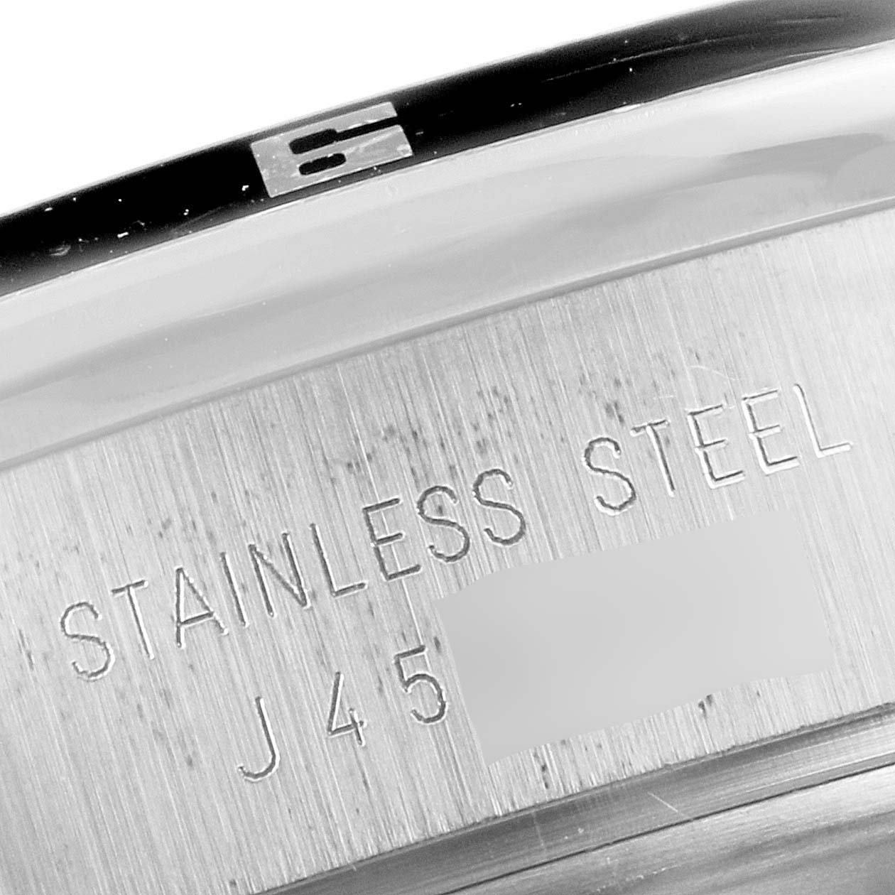 The image shows a close-up of the side of the Tudor Grantour 20530N Men
s Stainless Steel Silver Dial 20530N Men
s Stainless Steel Silver Dial watch, highlighting its stainless steel material and part of the engraved serial number.