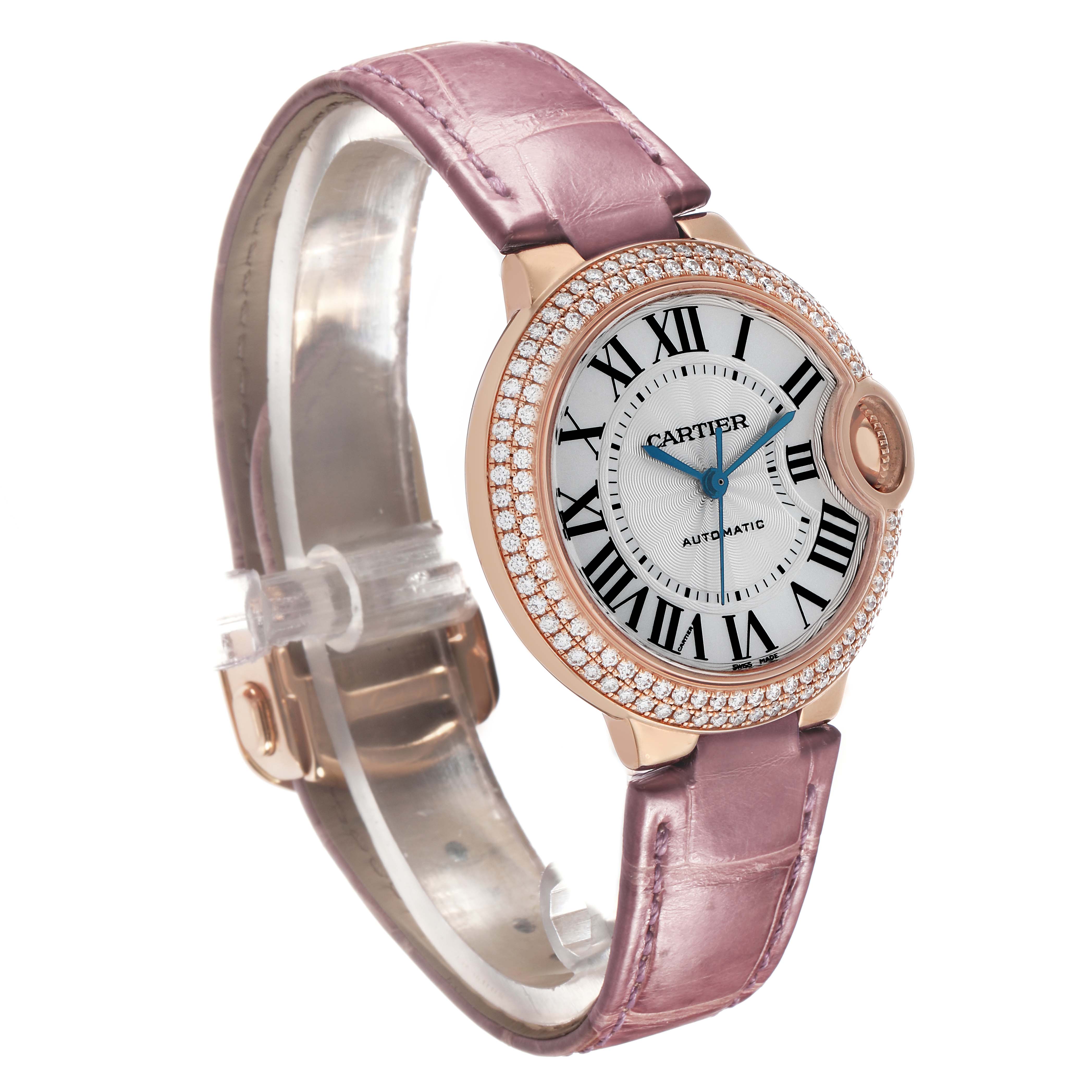 The Cartier Ballon Bleu WE902066 Women's Rose Gold Silver Dial watch is shown at an angled side view, highlighting its rose gold case, diamond bezel, and pink leather strap.
