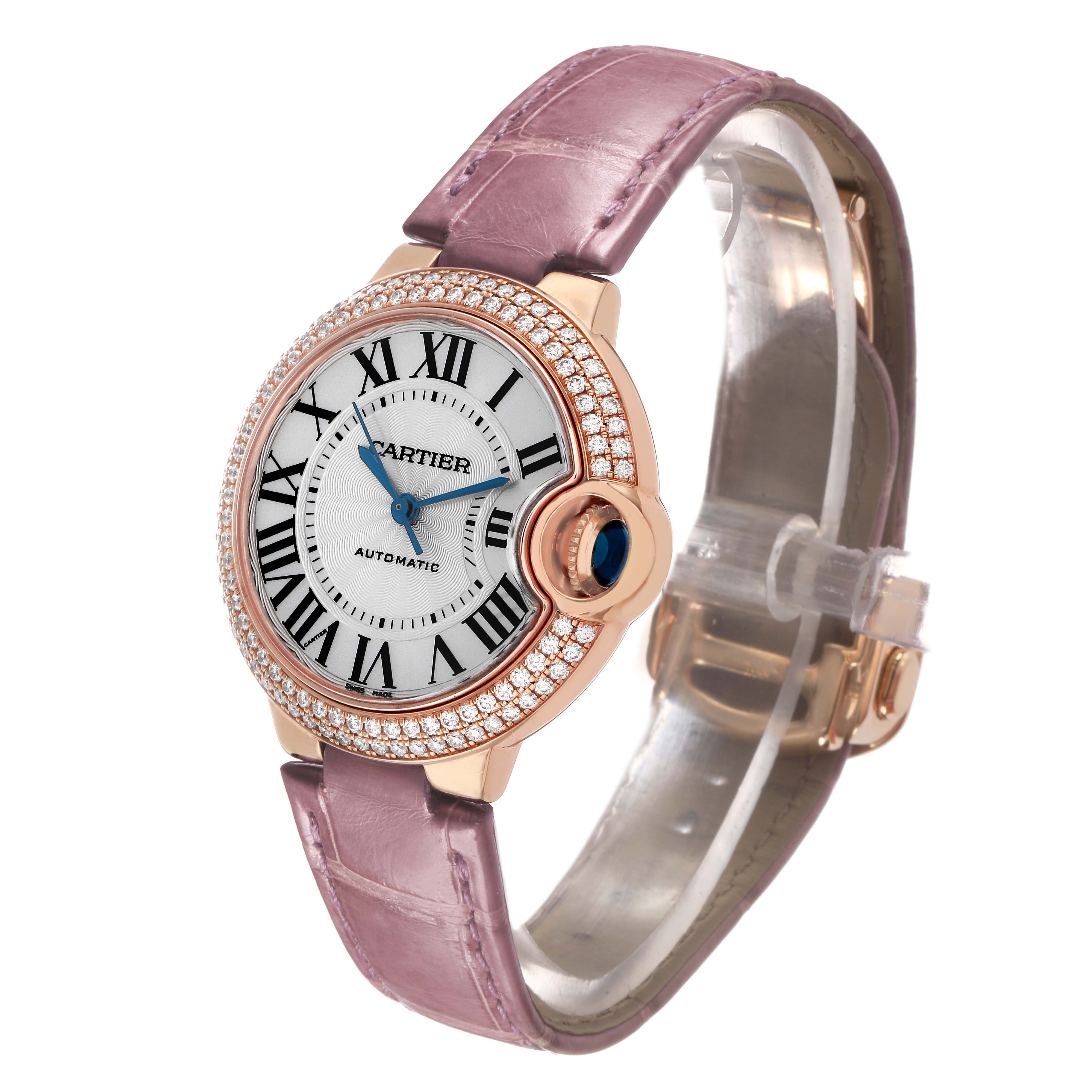 The Cartier Ballon Bleu WE902066 Women's Rose Gold Silver Dial watch is shown at a three-quarter angle, highlighting its round face, diamond bezel, and leather strap.